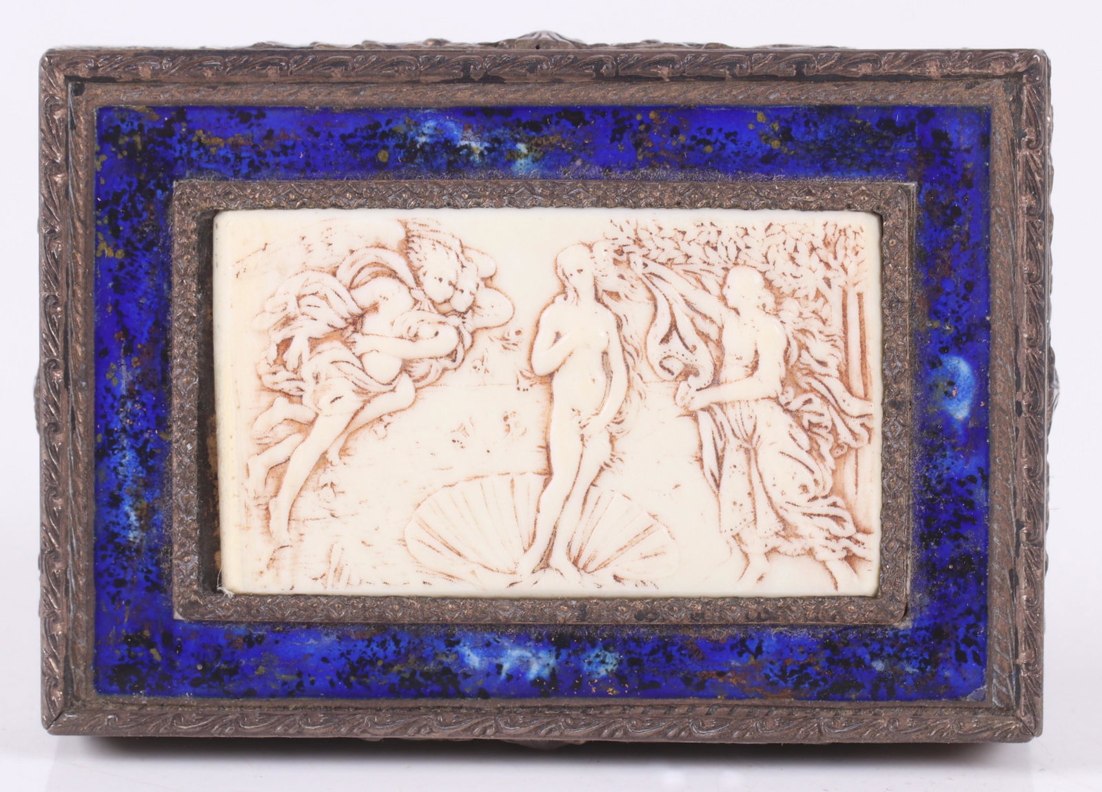 An Italian Silver, Bone and Enamel Box: The bone panel carved with "The Birth of Venus" which is framed in blue enamel, the exterior is decorated with masks and foliate engraving, the interior is gilt. Marked for .800 silver. Dimensions: 3"