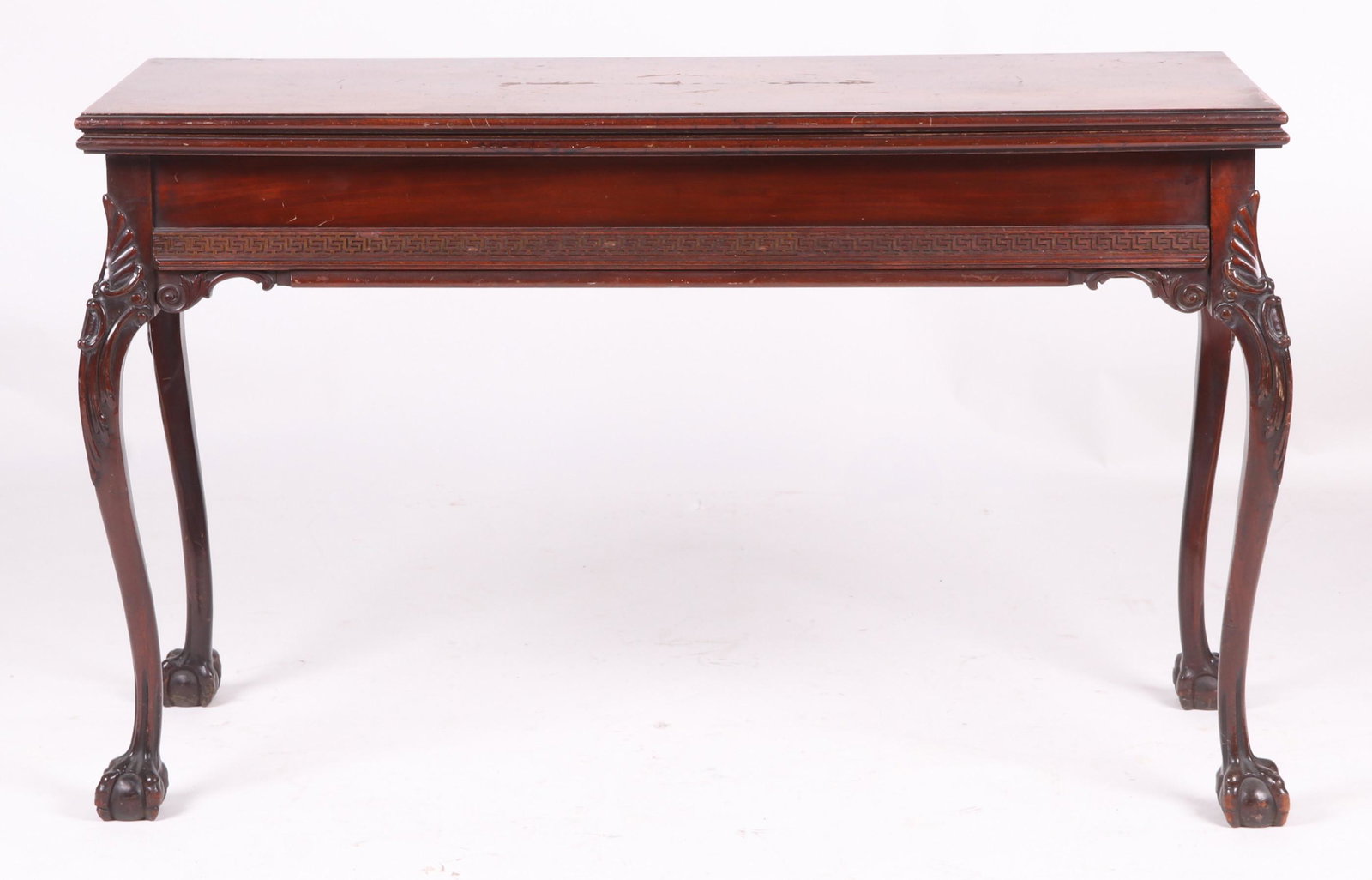 Chippendale Style Mahogany Dining Table: Circa 1900. With ball and claw feet, cabriole legs with carved knees and Greek key carved frieze. The table has an accordion like mechanism that allows three leaves to be hidden under the hinged top w