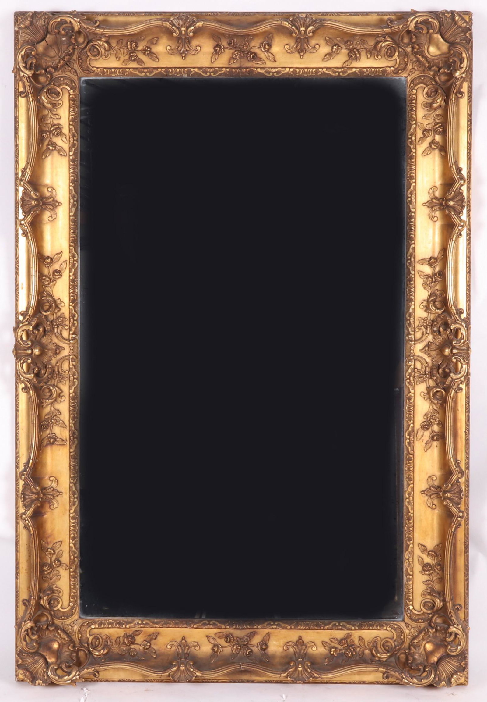 Large Gilt Gesso Mirror: Late 19th century, rectangular, with rococo style decoration which includes shells, acanthus leaf and floral elements. Dimensions: The interior measurement is 56" x 33 1/2". The exterior measurement i