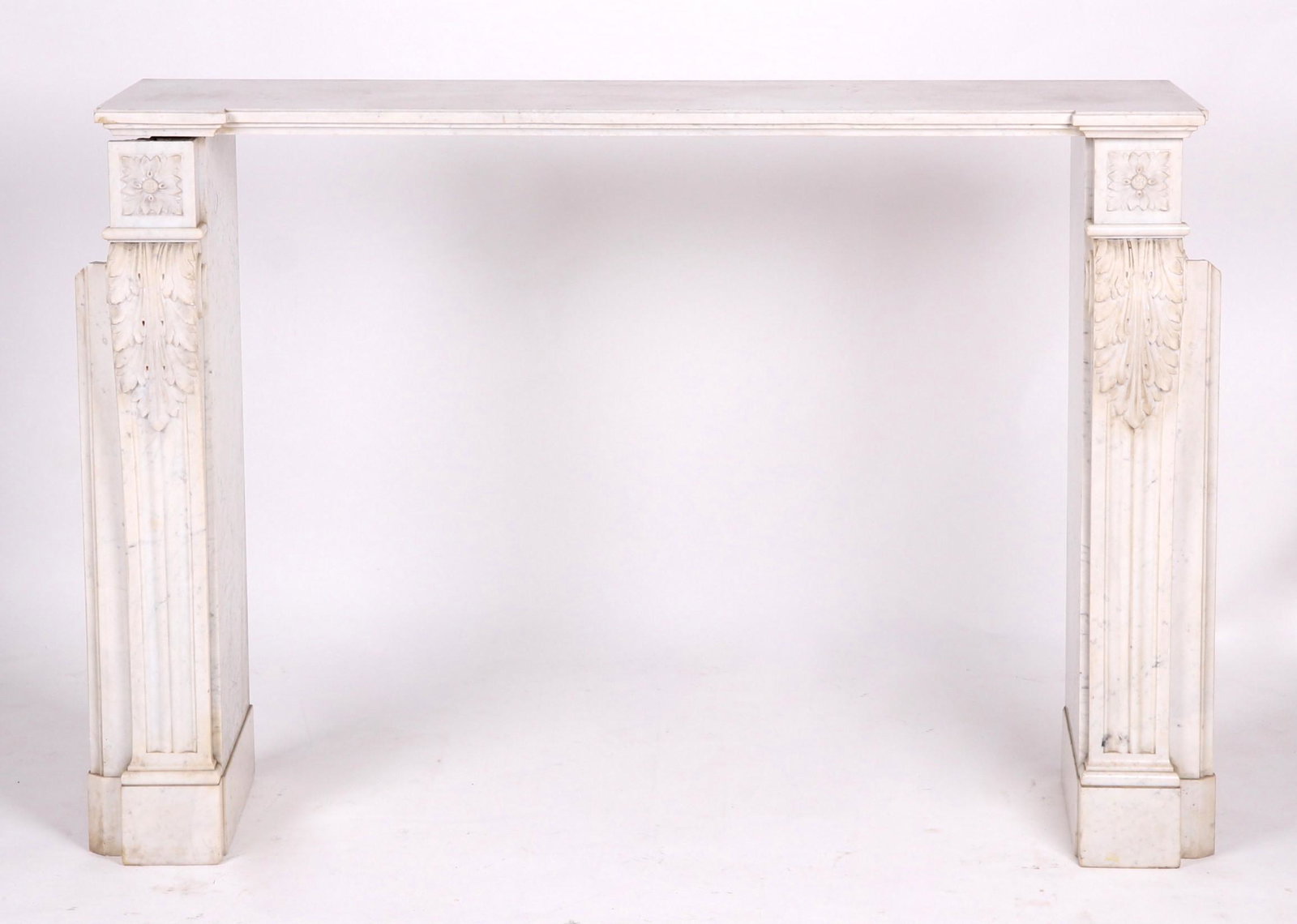 An Antique Marble Fireplace: White marble with Classical carving including fluting, scrolls, and acanthus leaves. In pieces some of which are broken as pictured Dimensions: The smallest section is 3" x 1 1/2" x 1 1/4". The larges