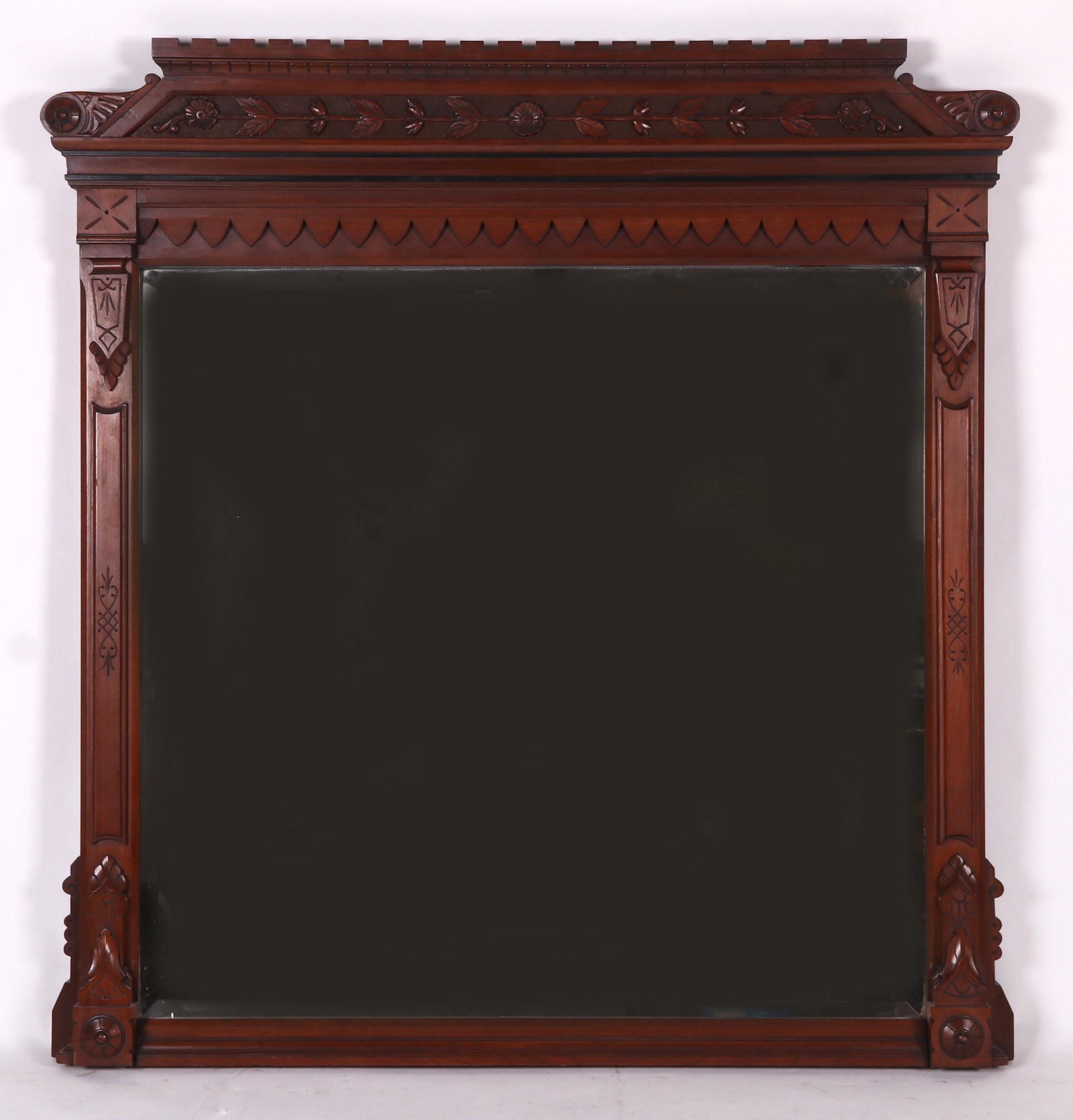 An Aesthetic Movement Walnut Mirror: Circa 1880, with stylized foliate and rosette carving. Dimensions: 60" x 55". Provenance: From a local estate.