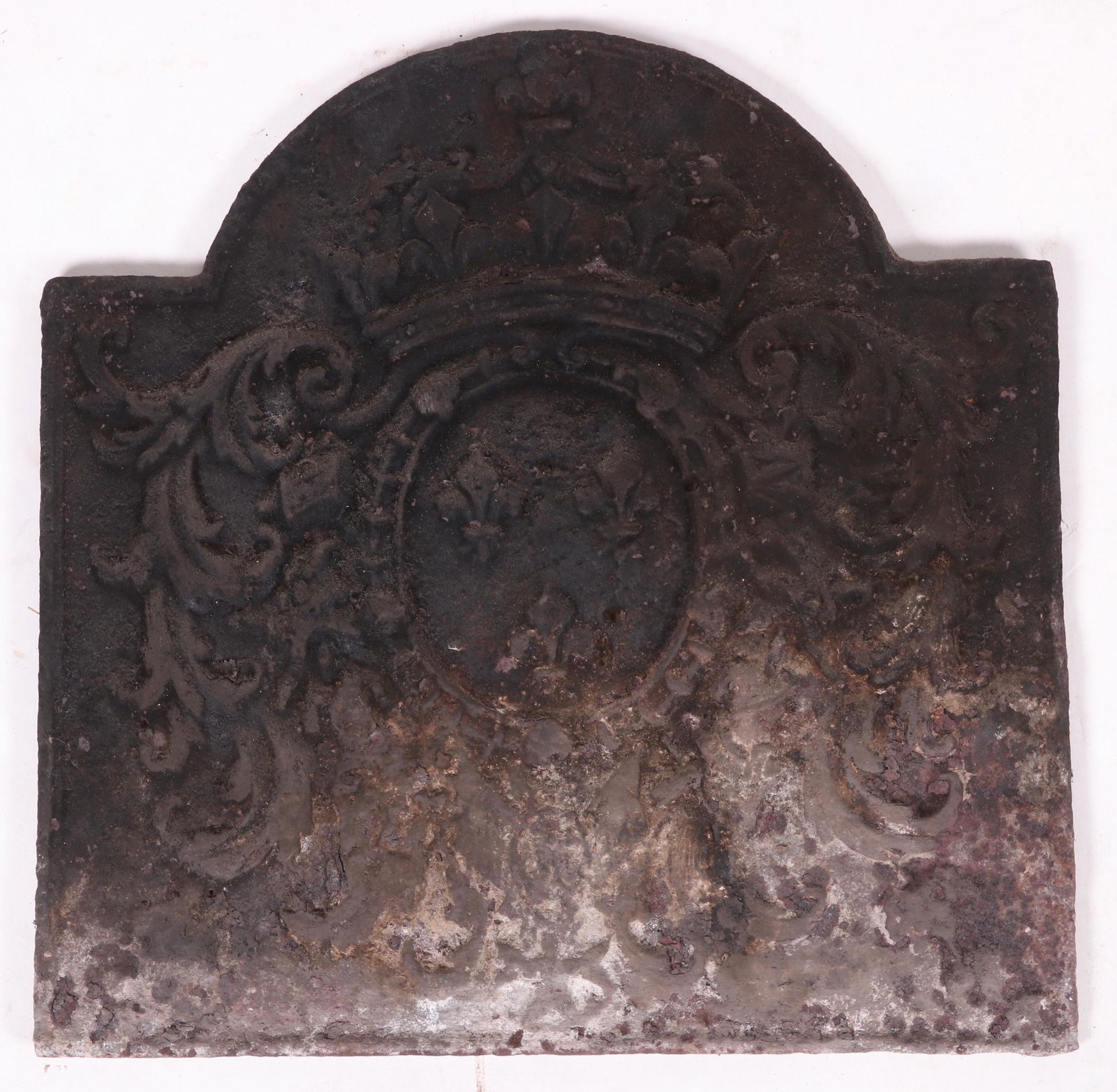 An Antique Cast Iron Fireback: Probably French. Tombstone form. Decorated with a low relief crest that features a crown and three fleurs de lis. Dimensions: 18 1/2" x 18 3/4", 1/2" thick. Provenance: From a Main Line Estate