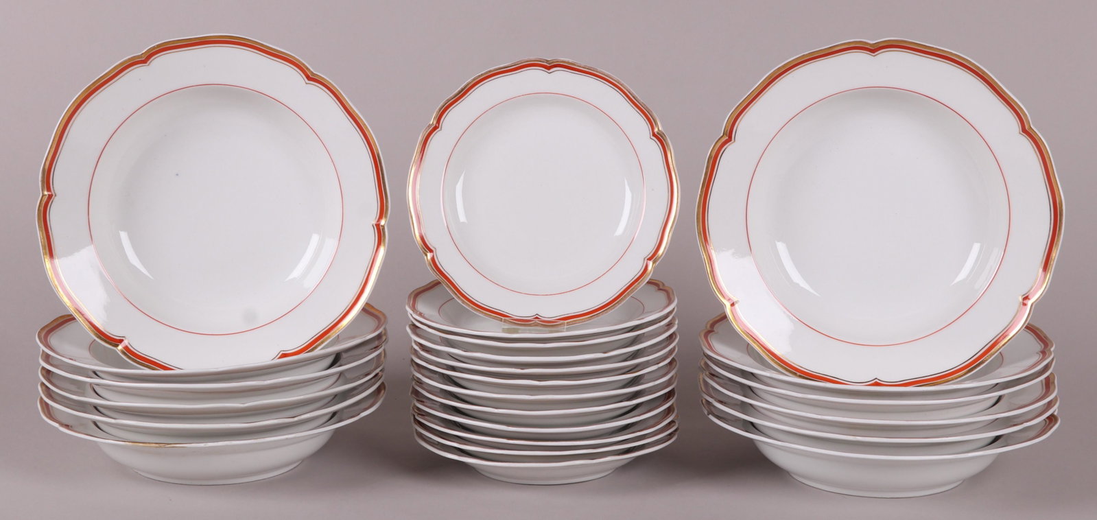 KMP Soup Bowls and Salad Plates, 19th Century: A set of twelve soup bowls and twelve salad plates, each with a crimson and gilt border, marked as pictured. Part of a larger service we are selling in this pattern, please check the other lots in thi