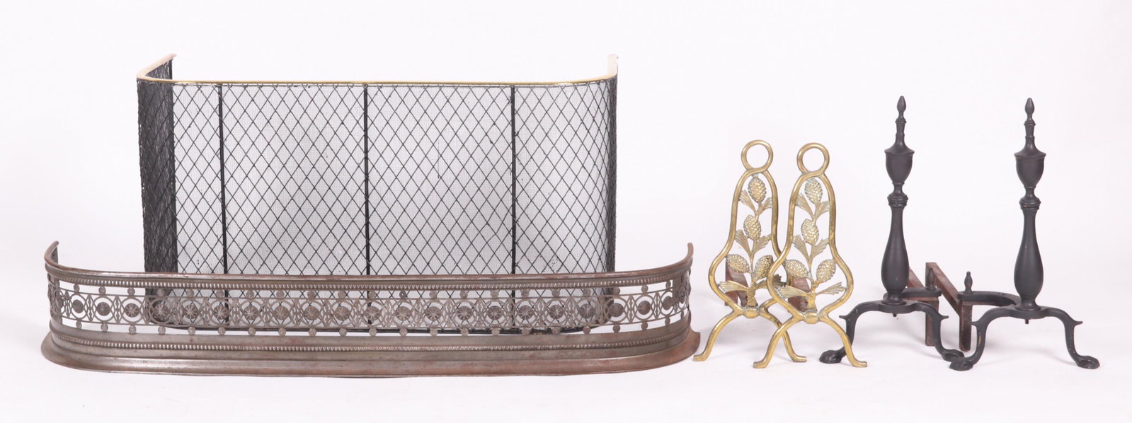 A Group of Fireplace Accessories: Comprising a pair of pine cone decorated brass andirons, a pair of Chippendale style black painted brass andirons, a steel fire fender with pierced and beaded decoration, and a wire and brass tall fir