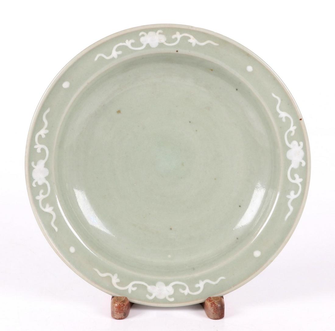 A Korean Celadon Bowl, 19th Century: With white slip decoration and a low circular foot. Dimensions: 10 7/8" in diameter, the height is 2". Provenance: From a Pittsburgh estate.