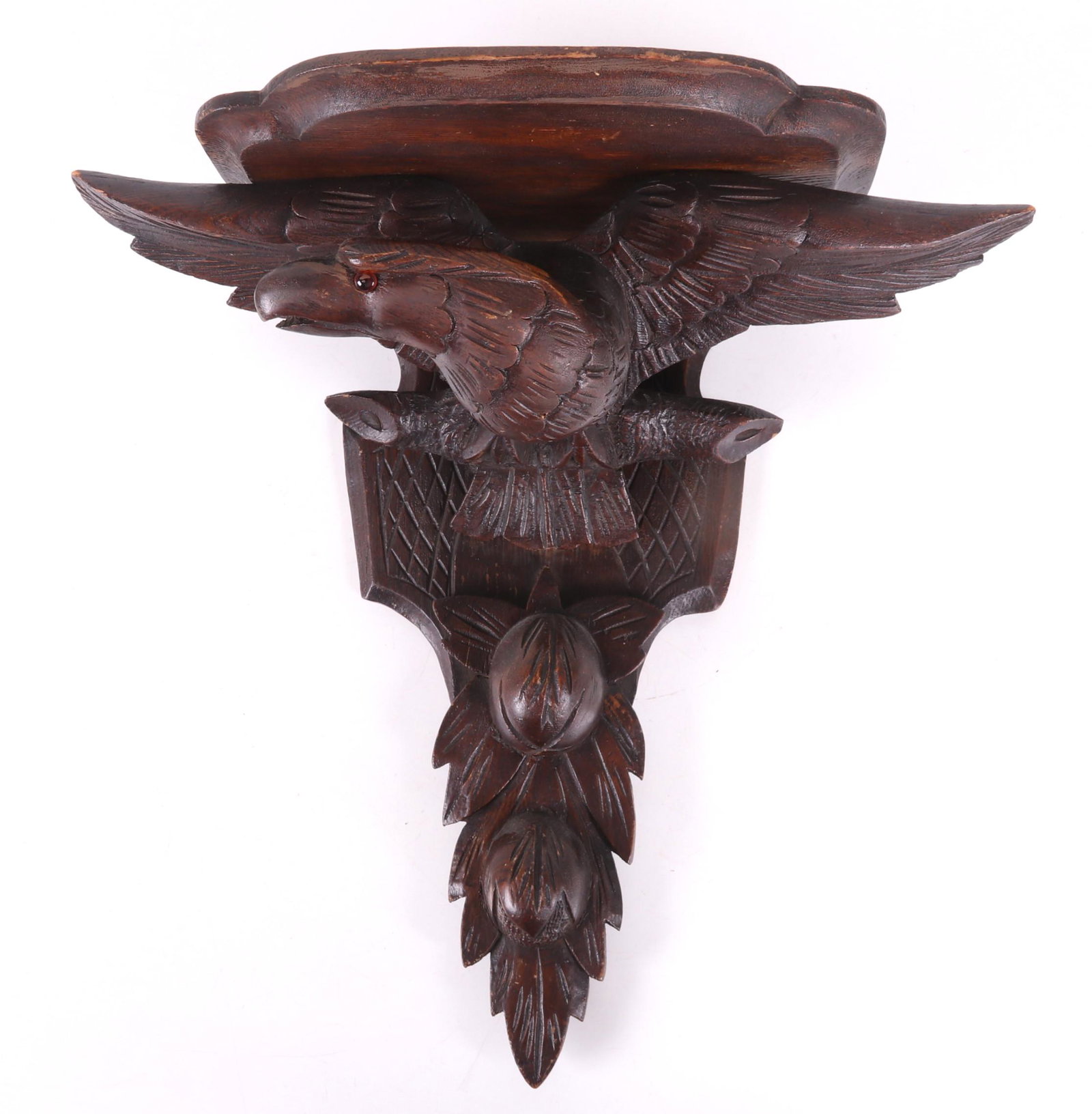 A Carved Eagle Decorated Wall Bracket: Late 19th century, the perched eagle with spread wings and a glass eye. Dimensions: 17" x 8 1/2", 18" tall.