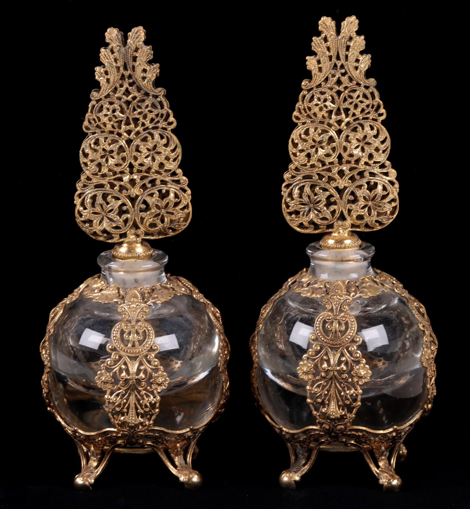 A Pair of Glass and Ormolu Perfume Bottles: From the first half of the 20th century, unmarked. Dimensions: Each is 3" in diameter and 7 1/4" tall.