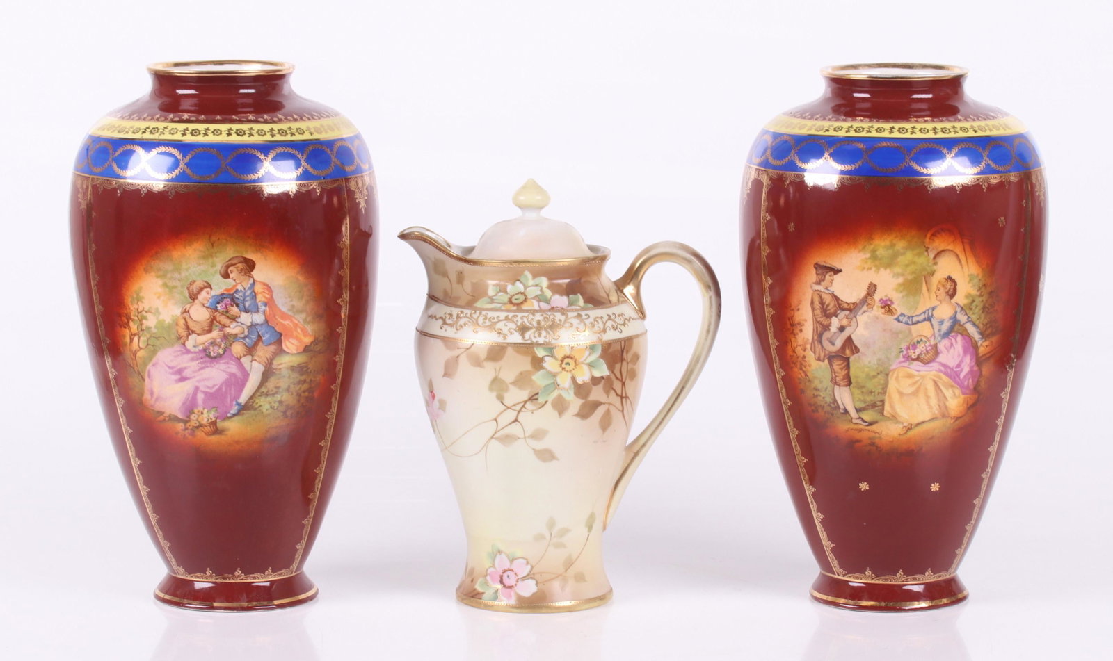 Porcelain, Nippon and German: All 20th century, a pair of large transfer decorated Vienna style German vases and a Nippon chocolate pot. Dimensions: The pot is 7" x 5" and 10" tall, each vase is 7" in diameter and 12" tall.