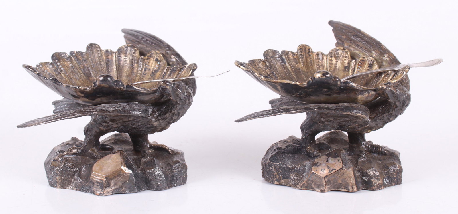 Pair of Eagle and Shell Silver Plated Master Salts: Each in the form of an eagle on a rocky mound supporting a large shell. Unmarked. With associated circa 1860 coin silver salt spoons marked for George Eno. Dimensions: Each is 4 1/2" x 4 1/2" and 3 1/