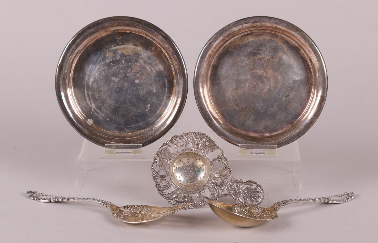 A Group of Sterling Silver Tableware: Comprising: a silver plated Continental rococo style strainer, a sterling salad set by Dominick and Haff in the blossom pattern, and a pair of unmarked silver (unknown quality) wine coasters. Dimensio