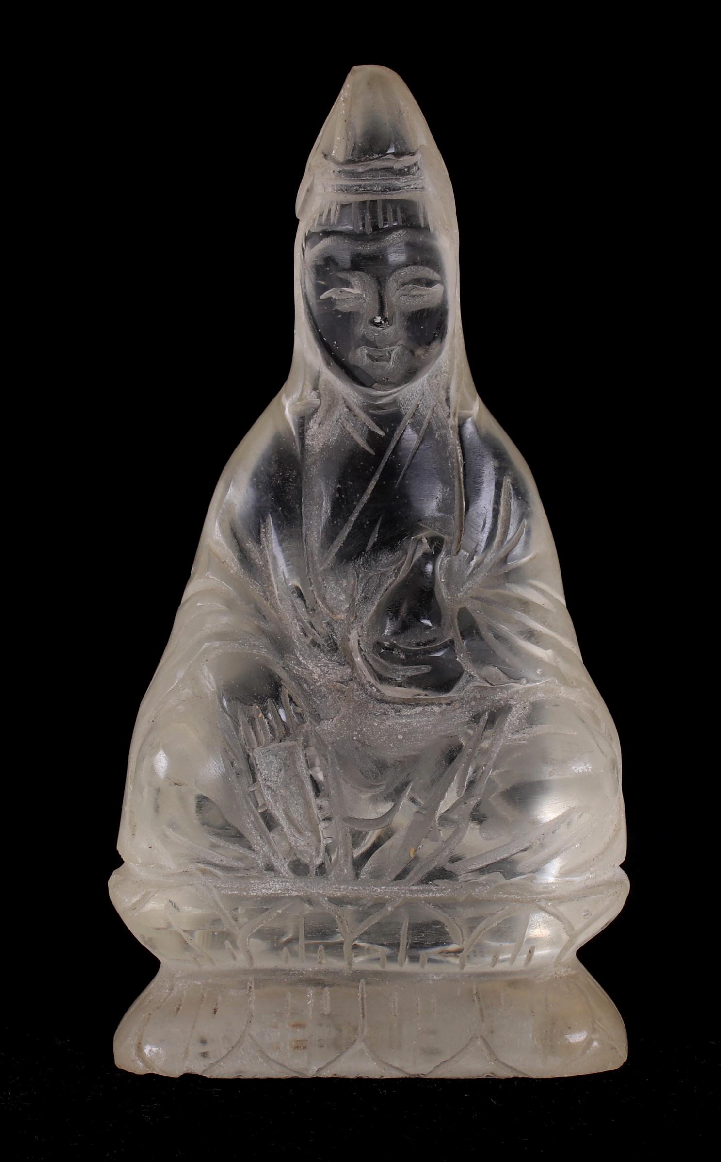 A Chinese Carved Glass Figure: Depicting Guanyin seated on a double lotus base and holding a vessel. Dimensions: 2 3/4" x 1 1/2", 4 3/4" tall. Provenance: From a PA estate.