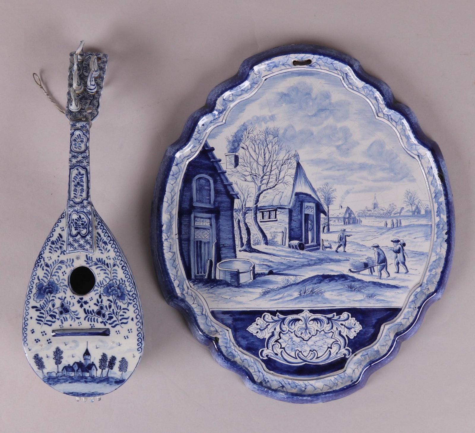 Two Pieces of Pottery, French and Delft: Both 19th century a nearly life sized French wall hanging in the form of a mandolin and a plaque marked for Royal Tichelaar Makkum. Dimensions: The plaque is 16" x 13 1/2", the mandolin is 3 1/2" x 5"