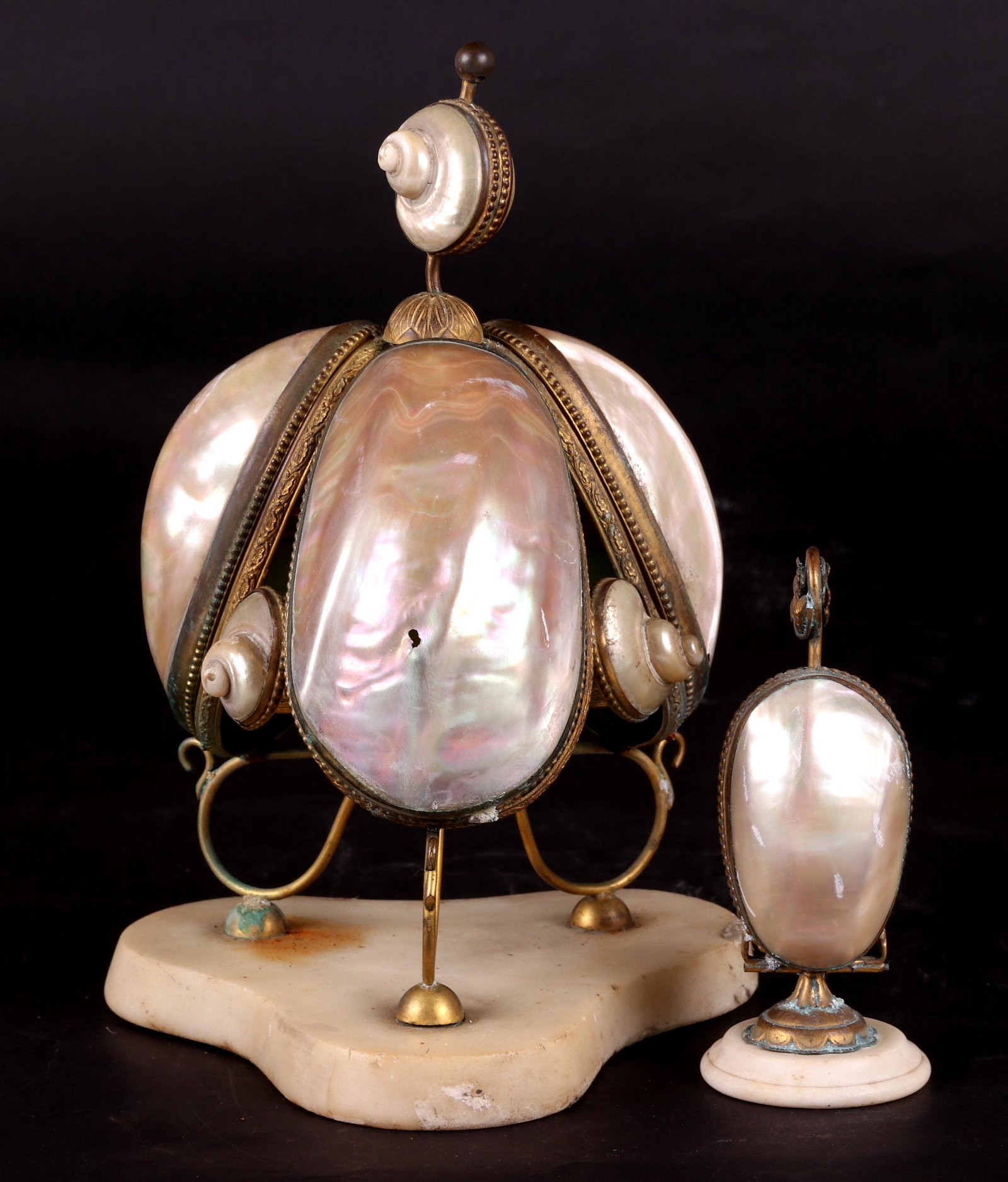 Two French Perfume Stands: 19th century, each with a marble base, glass bottles and ormolu mounted mother of pearl covers. Dimensions: The smaller is 2 1/2" in diameter and 6" tall, the larger is 7" in diameter and 11" tall. Pr