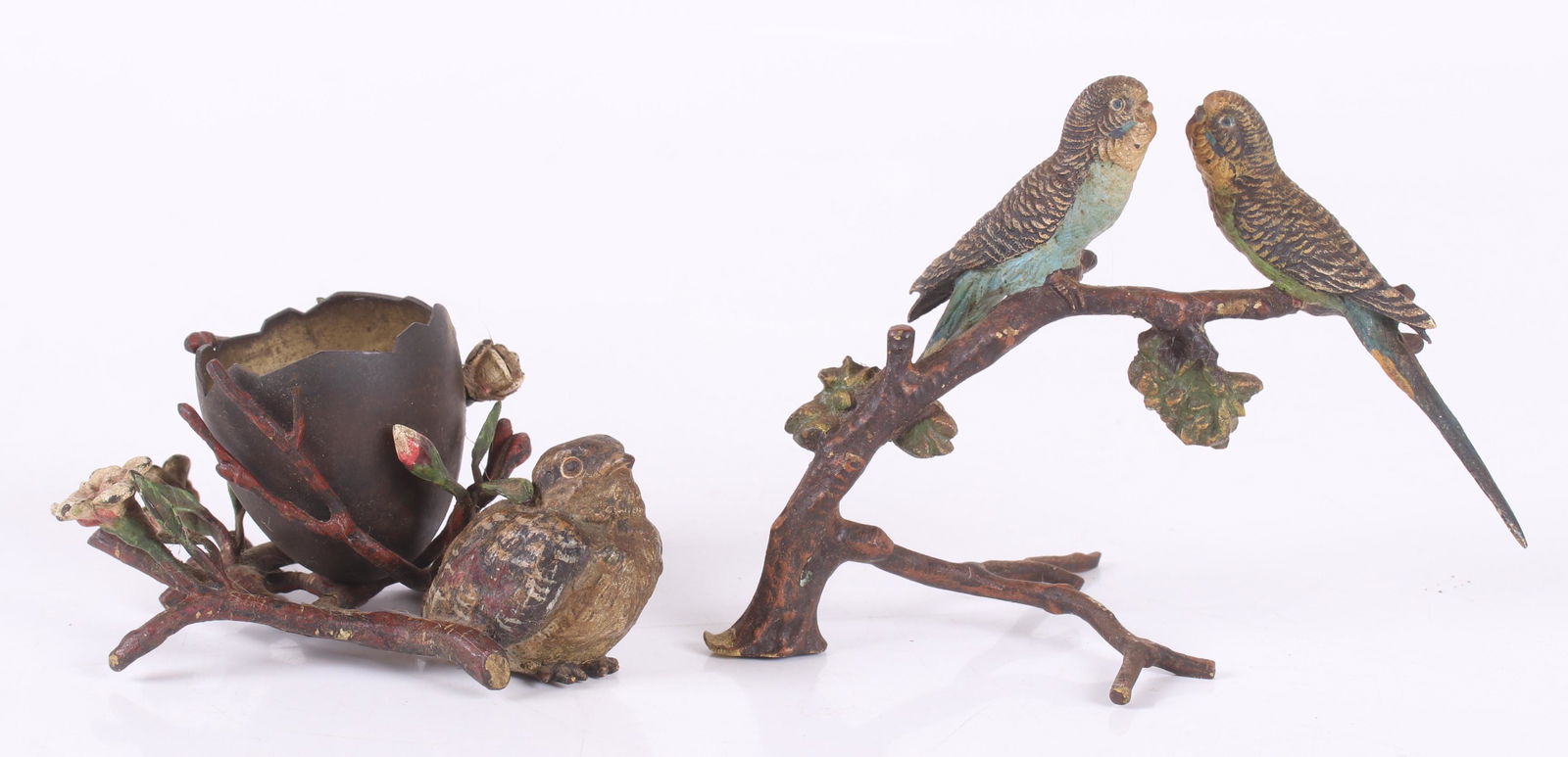 Two Vienna Cold Painted Bronze Items: A broken egg form toothpick holder decorated with flowers and a single bird and a whimsy in the form of a branch with two perched parakeets. Dimensions: The toothpick is 4 1/2" x 3 1/2" and 2" tall, t