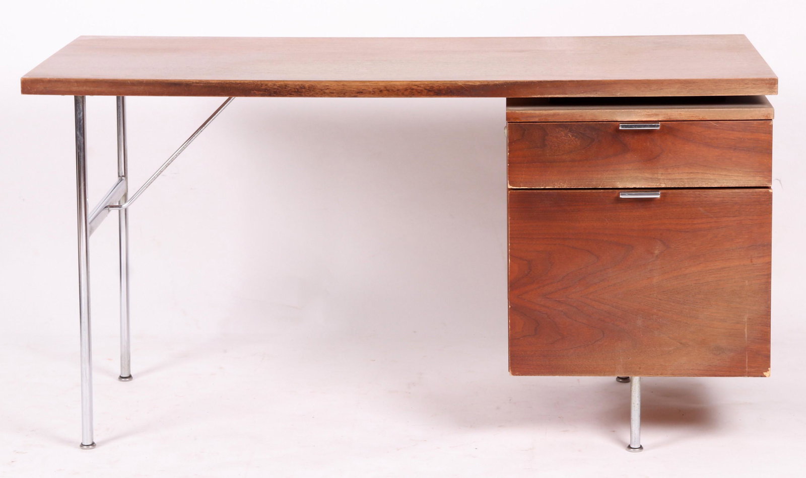 George Nelson for Herman Miller, Desk: Walnut and chrome, with a single bank of drawers. Dimensions: 53" x 25", the height is 28". Provenance: From a Princeton collection.
