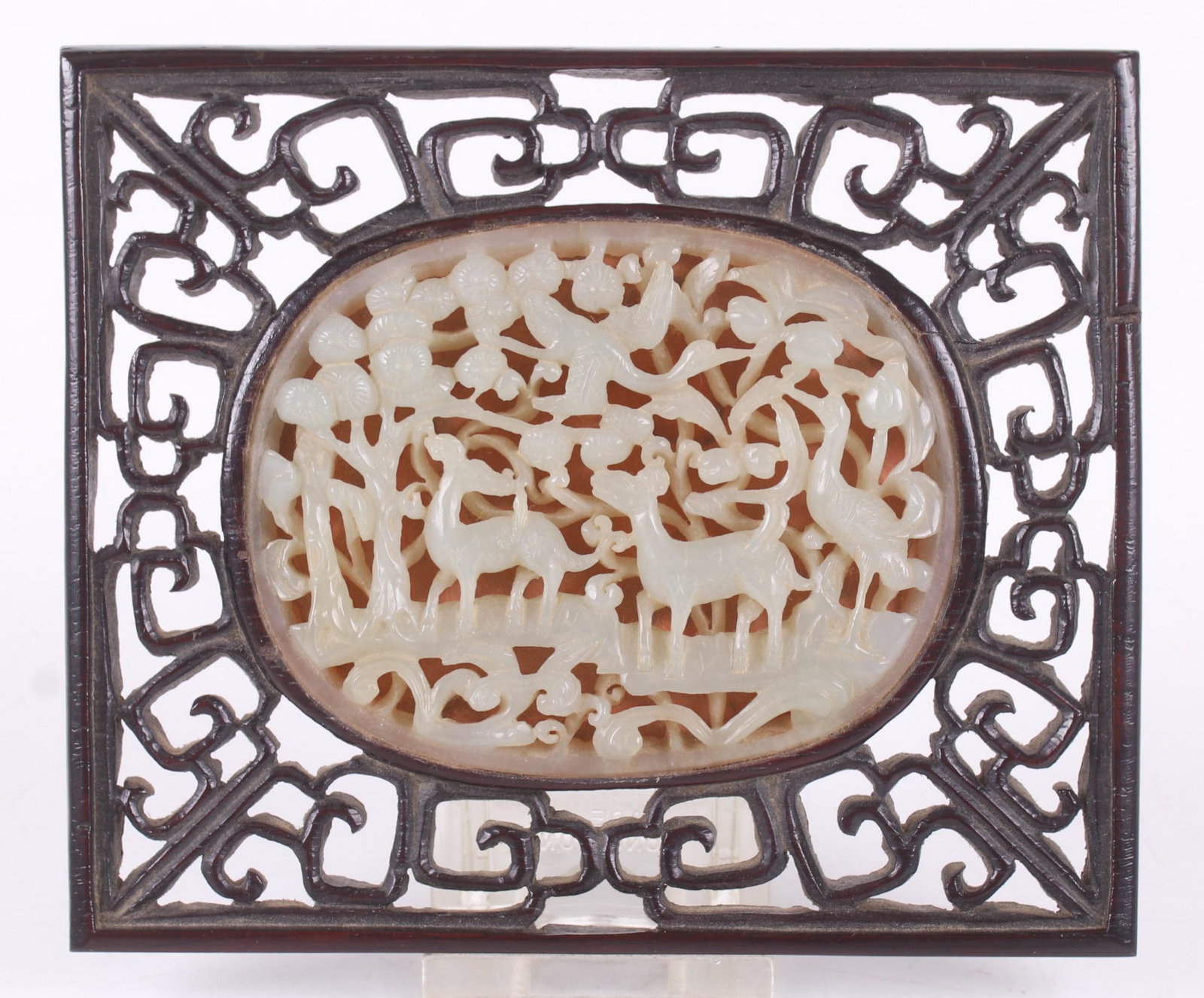 A Chinese Jade Plaque: Qing dynasty, an open-work example depicting deer in a natural setting. With original pierced wooden frame. Dimensions: The jade is 2 1/2" x 3 1/2", the frame is 4" x 5". Provenance: From a Princeton