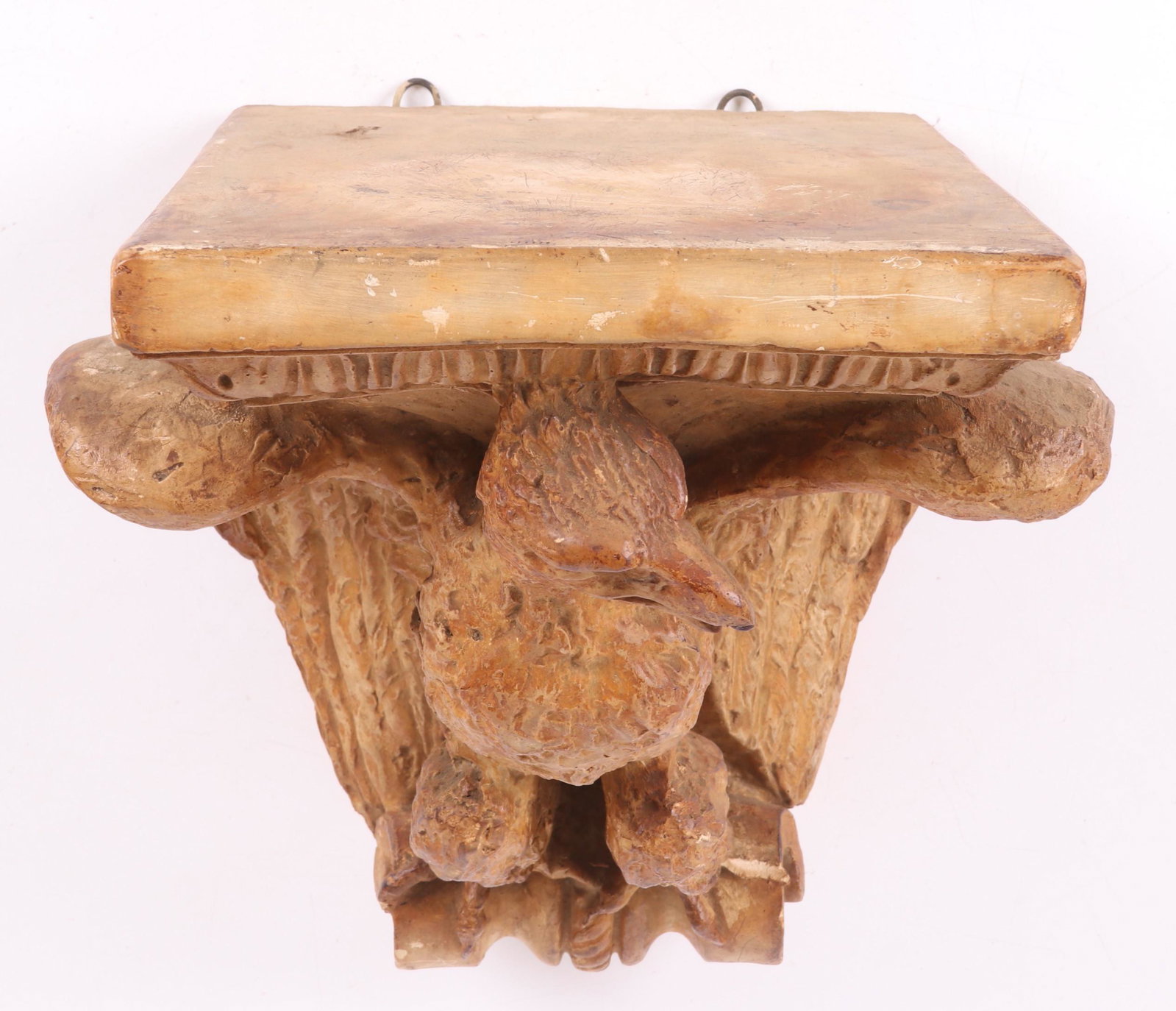 A Plaster, Eagle Wall Bracket: 20th century, with a faux wooden painted surface. Dimensions: 11" x 12 1/2", the height is 14" tall.