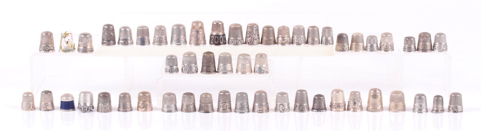 A Group of 52 Sterling Silver Thimbles: All with various decoration, some engraved, others have raised decoration. Dimensions: Various sizes, the total approximate weight is 8.2 troy ounces. Provenance: From a local estate.