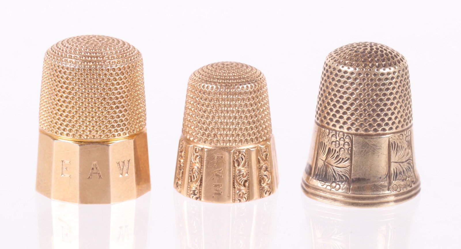 Three 14k Gold Thimbles: Each with a lower paneled body, two with engraved decoration. Dimensions: The approximate combined weight is 9.4 dwt. Provenance: From a local estate.