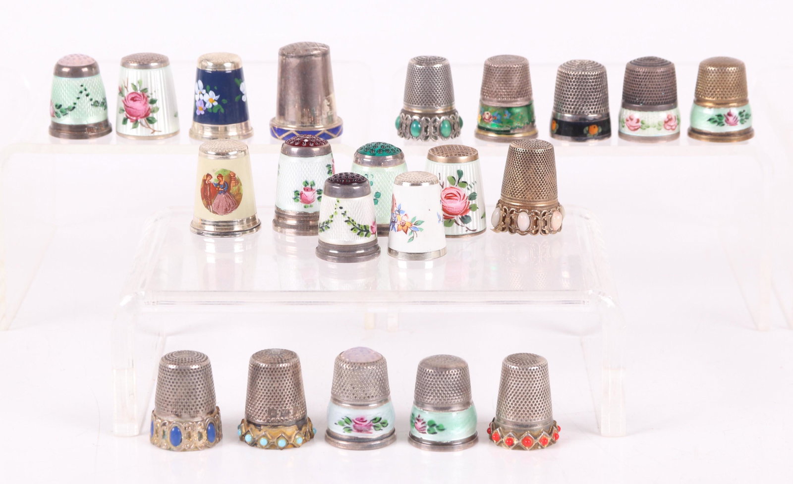 A Group of 21 Silver and Enameled Thimbles: American and European, most with floral decoration. Dimensions: The total approximate gross weight is 3.5 troy ounces. Provenance: From a local estate.
