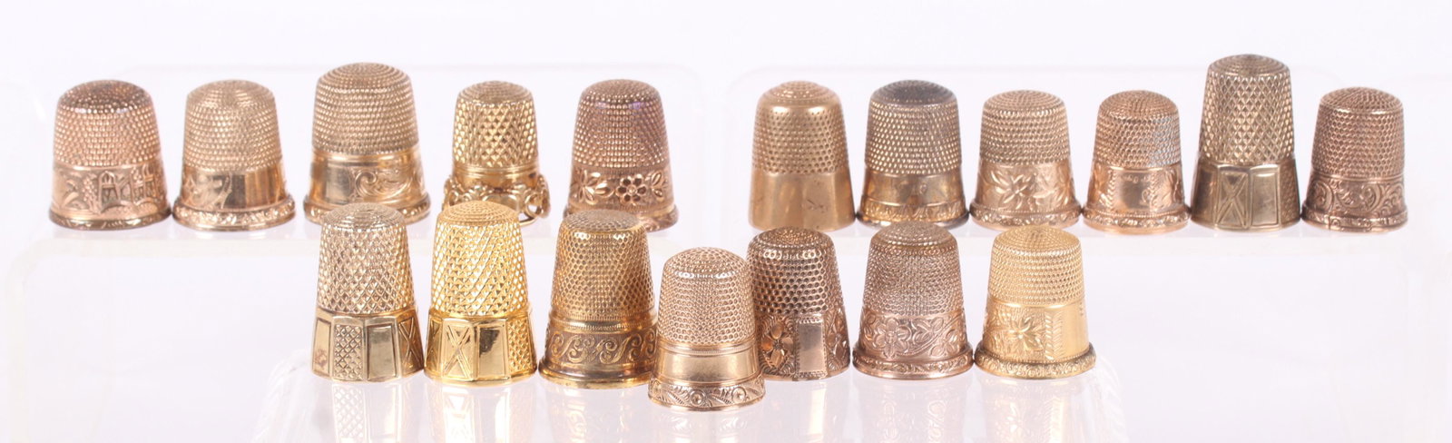 A Group of Gold Filled or Vermeil Thimbles: Eighteen examples, each with decoration, late 19th or 20th century. Dimensions: Various sizes, the total approximate weight is 2.7 troy ounces. Provenance: From a local estate.