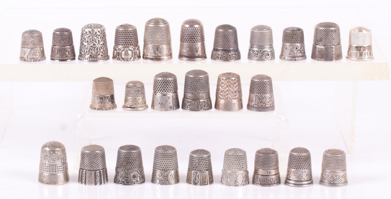 Twenty Six Sterling Silver Decorated Thimbles: Various sizes and decoration, makers include Simons Brothers and Ketcham and McDougall Dimensions: From size 5 to 11, the total approximate weight is 3.96 troy ounces. Provenance: From a local estate.