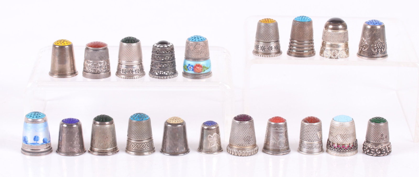 A Group of Glass Topped Silver Thimbles: Twenty examples, various sizes and decoration. Most are European. Dimensions: The total approximate gross weight is 2.8 troy ounces. Provenance: From a local estate.