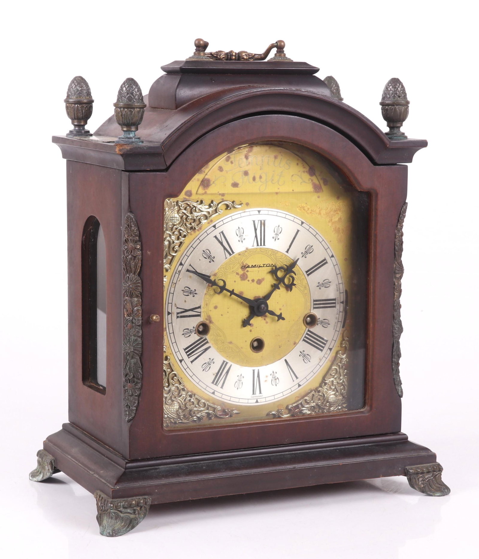 A Hamilton Bracket Clock: Circa 1970 , with a mahogany case and brass dial, with a brass plaque that indicates the clock as a reward for 25 years of employment at the Campbell Soup co. Dimensions: 11 1/2" x 7", the height is 1
