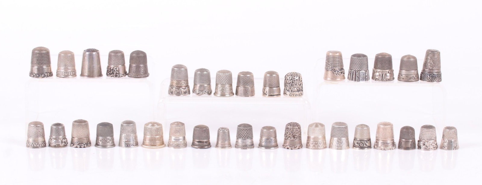 Thirty Five Sterling Silver Thimbles: Almost all with decoration, late 19th and 20th century. Dimensions: Various sizes. The total approximate weight is 5.4 troy ounces. Provenance: From a local estate.