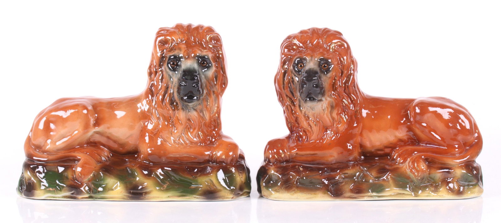 A Pair of Large Staffordshire Lions: Circa 1880, each in a reclining position and with glass eyes. Dimensions: Each is 13" x 5 1/2" and 9 3/4" tall.