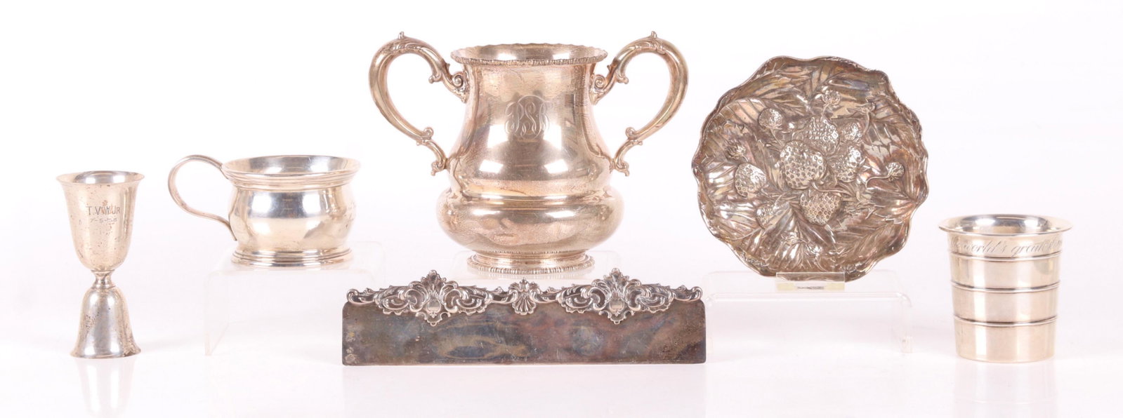 Sterling Items Including, Loving Cup, Etc...: Comprising: a measuring cup marked for Towle, a heavy child's cup marked for Dominick and Haff, a Jigger by Boardman, a bowl with repousse decoration by Gorham, a rococo decorated ruler marked for Lud