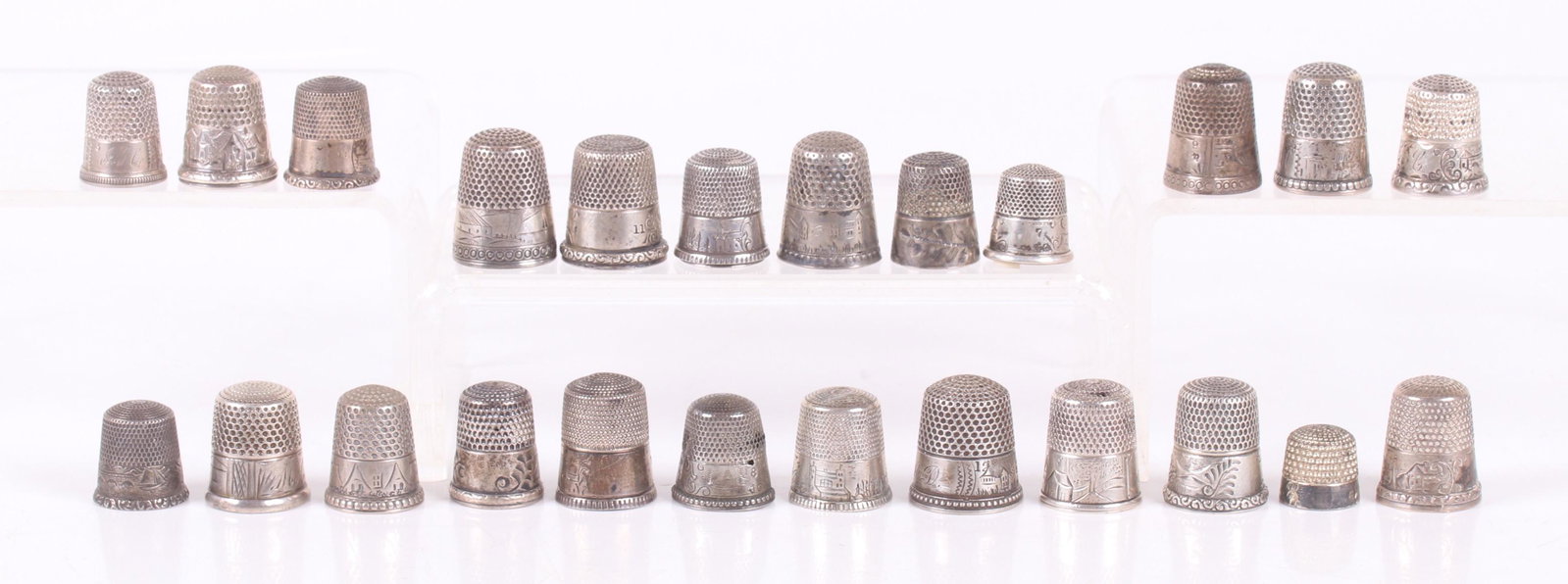 25 Sterling Silver Landscape Decorated Thimbles: Various sizes and decoration, makers include Simons Brothers and Waite, Thresher Co. Dimensions: From size 6 to 12, the total approximate weight is 3.27 troy ounces. Provenance: From a local estate.