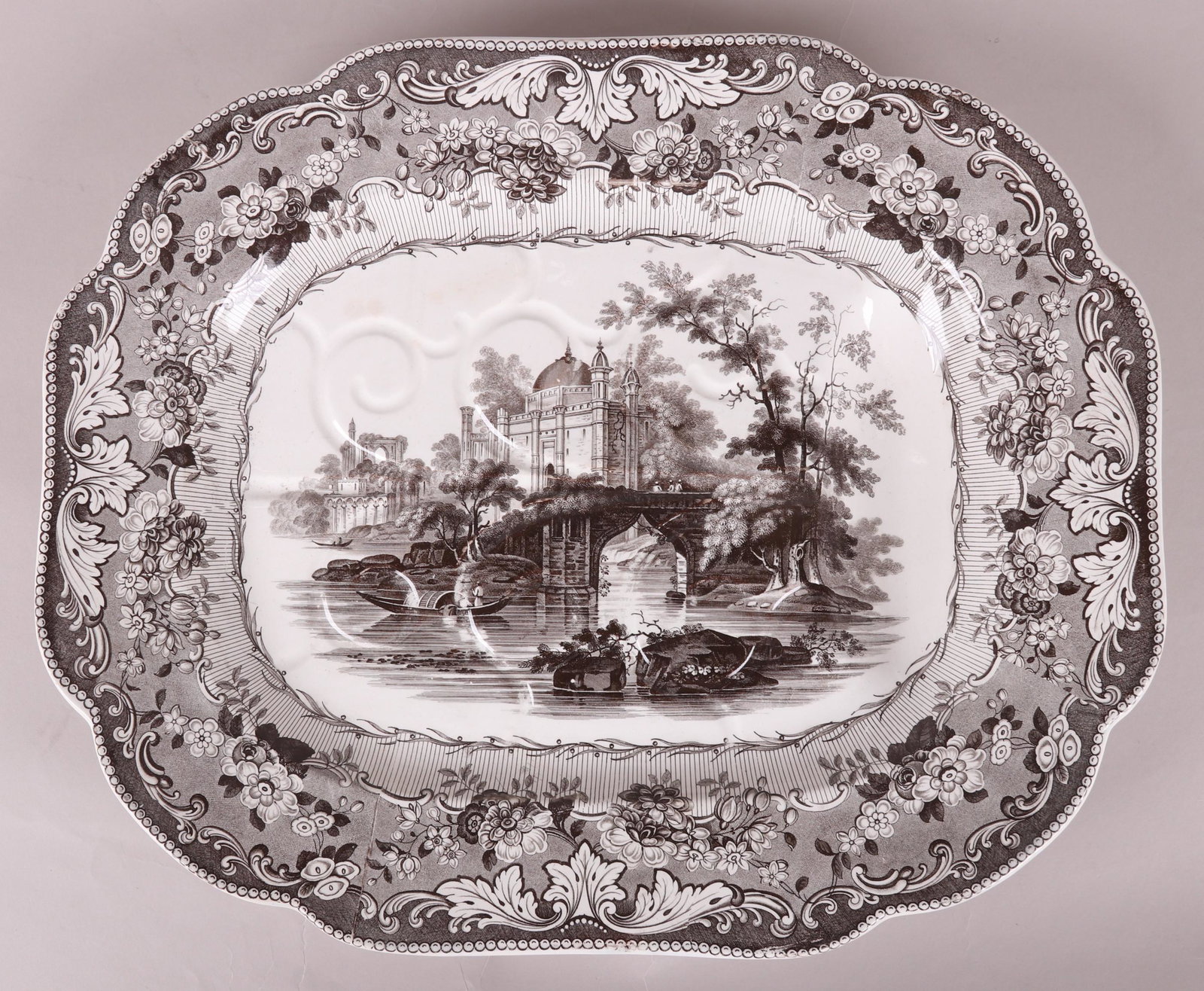 A Staffordshire Transferware Tree & Well Platter: In the 'Dacca" pattern by Minton and Boyle circa 1835. Brown transfer with with feet that tilt to direct liquid to the well. Dimensions: 21" x 17", 2 1/2" tall. Provenance: From a local collection.