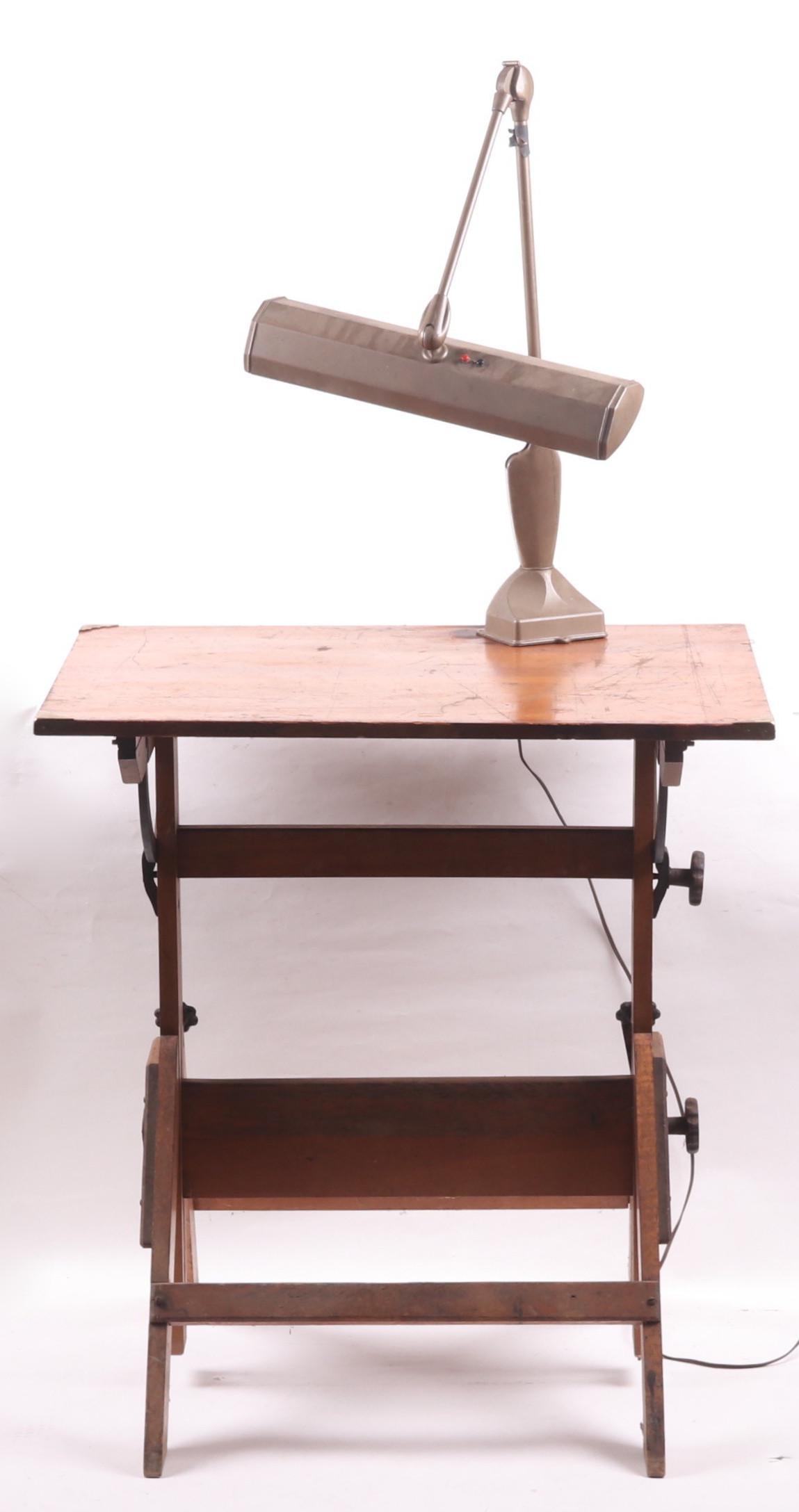 A Vintage Drafting Table with Lamp: Mid 20th century, an adjustable table with industrial metal lamp. Dimensions: 31" x 23", 33" tall. Provenance: From a Philadelphia estate.