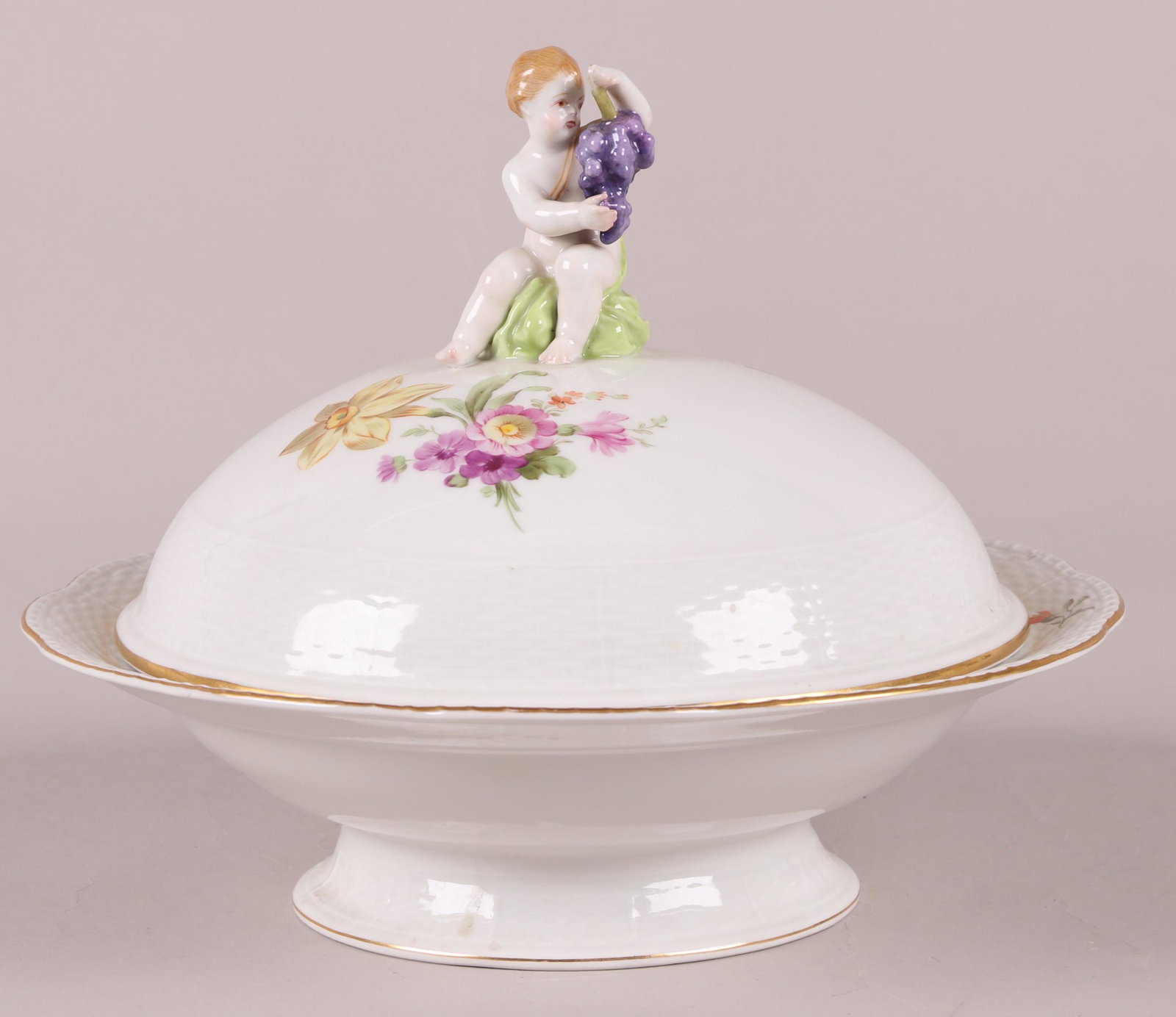 A KPM Porcelain Covered Server: 19th century, with a low foot, hand painted floral decoration and a lid with putto finial. Marked as pictured. Dimensions: 11" in diameter, the height is 10". Provenance: From a local collection.