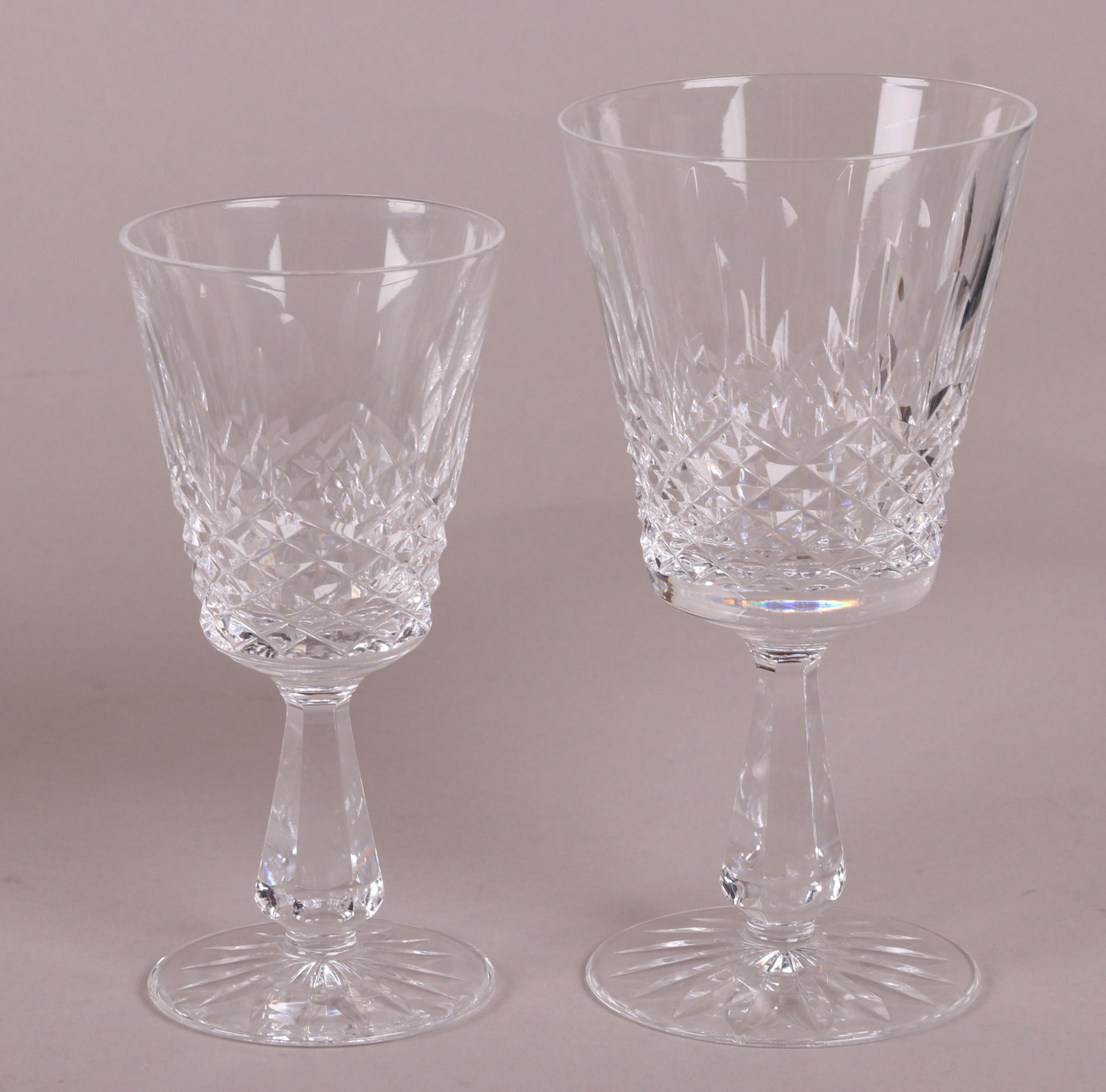 A Set of Waterford Lismore Pattern Stemware: Twelve 6 3/4" water goblets and nine 6" tall wine glasses. Dimensions: See description for measurements. Provenance: From a local collection.