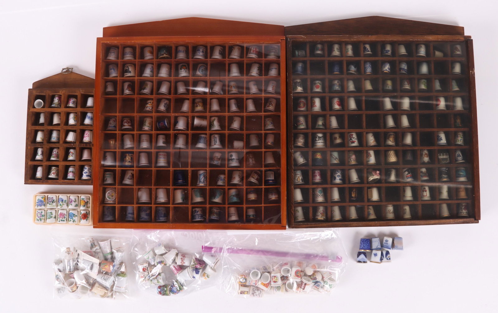 A Large Group of Porcelain Thimbles: All 20th century, hundreds of examples, various decoration and makers. Dimensions: The cases range from 9" x 6" x 2" to 17" x 11" x 2". Provenance: From a local estate.