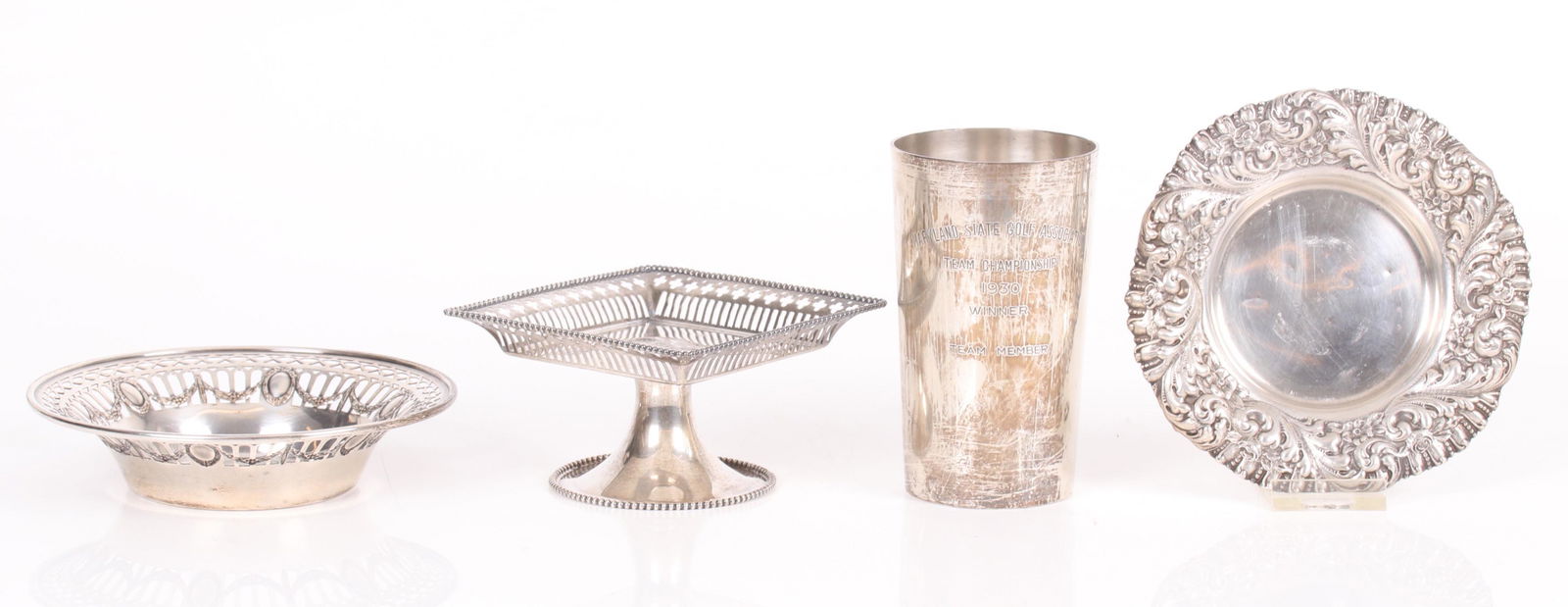 Four Pieces of Sterling Silver: Comprising: a trophy for a 1930 golf tournament by S. Kirk and Son, a small calling card tray by Whiting, a wine bottle coaster with a reticulated edge by Durgin and a repousse wine bottle coaster by