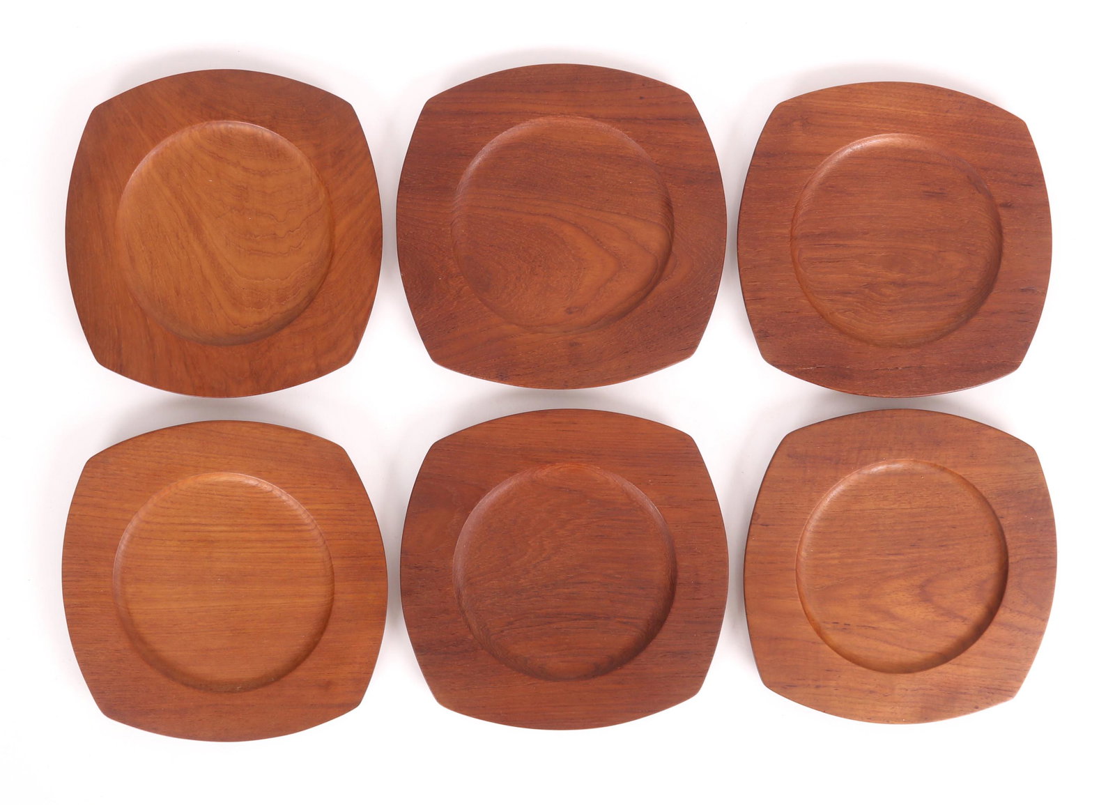 A Set of Danish Teak Plates, Poul Knudsen: Six plates, circa 1950, each with in a square form with arched edges, marked as pictured. Dimensions: Each is 10 1/2" in diameter.