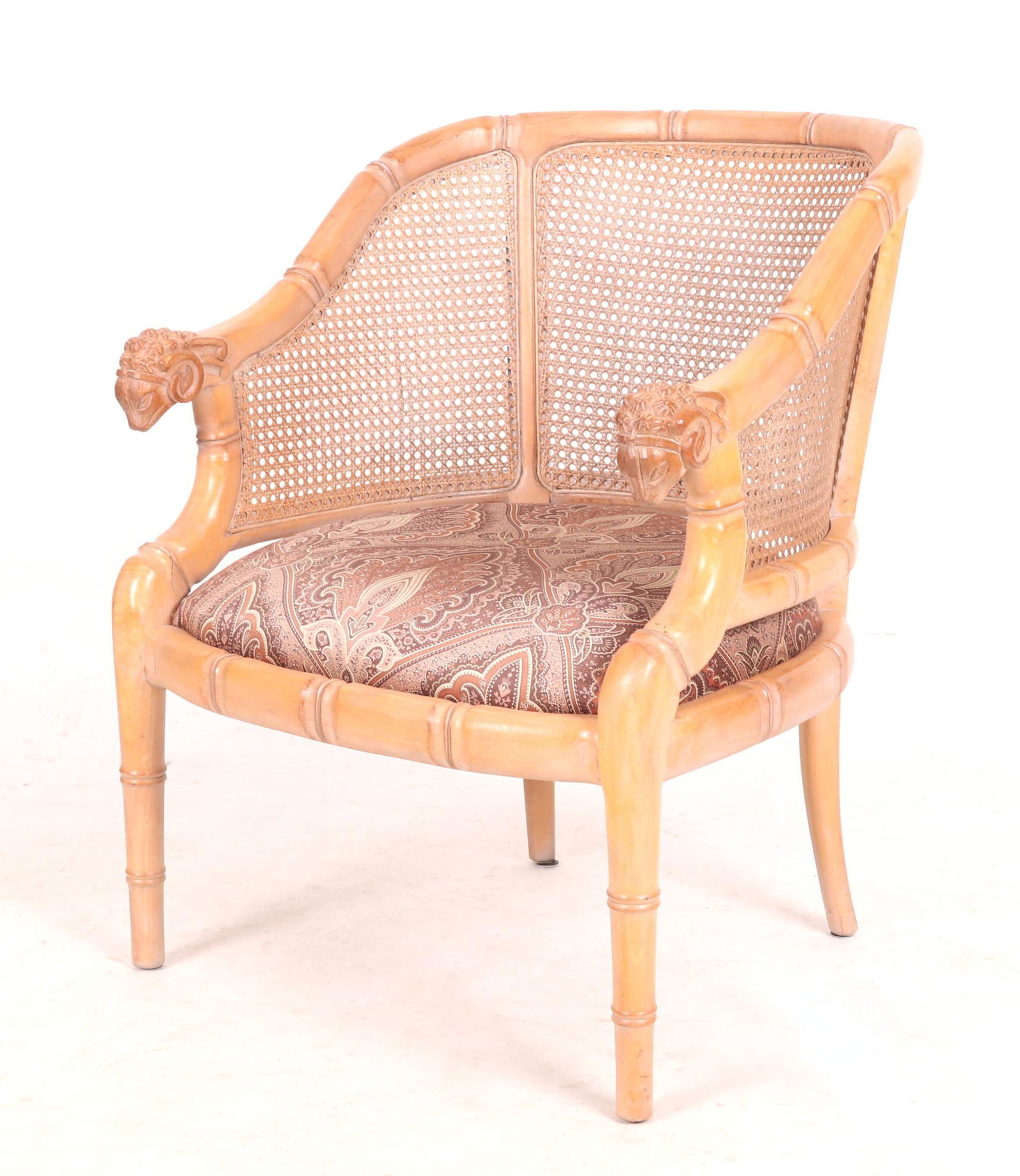 A Decorative Armchair: 20th century,with a faux bamboo carved frame, ram's head handholds and a caned back. Dimensions: 26" arm to arm, the seat height is 17" and the overall height is 32".