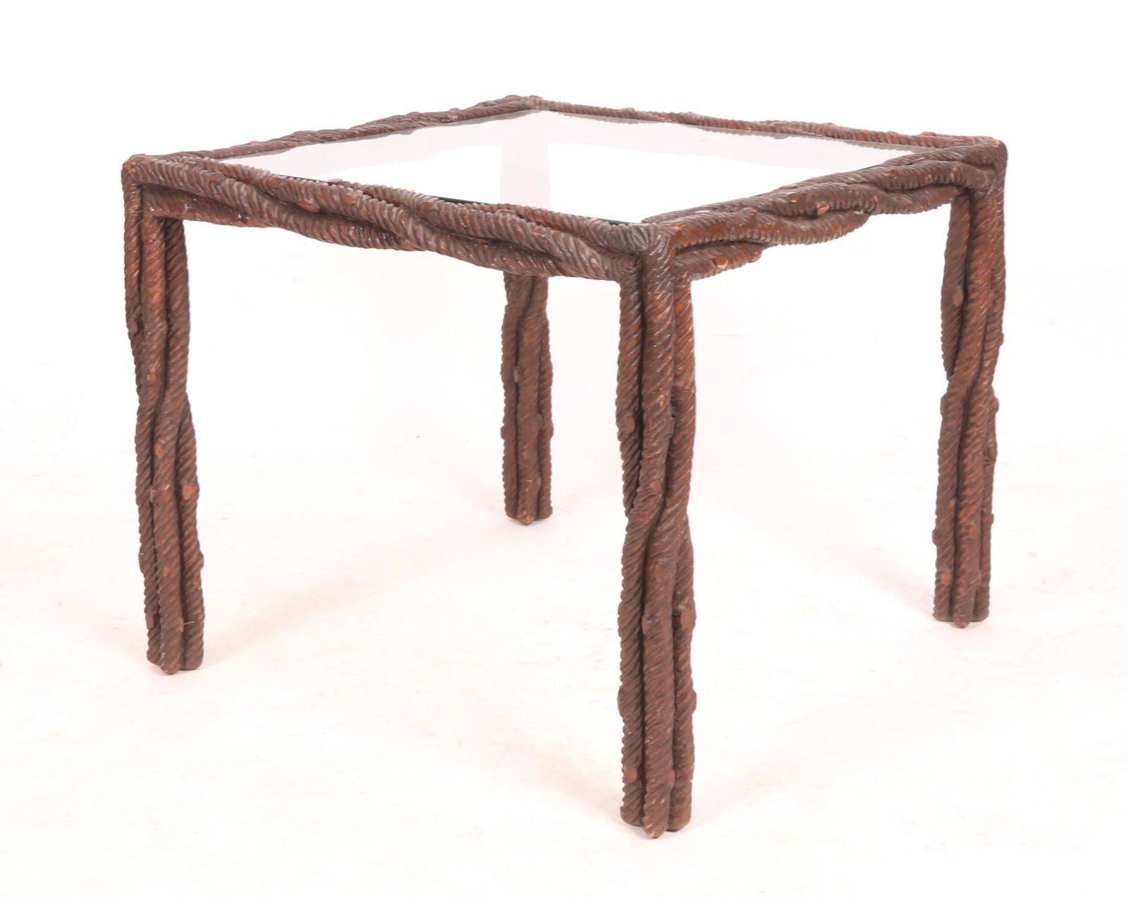 Branch Carved and Glass Table: A wooden table carved in the manner of intertwined branches, with a glass top, 20th century. Dimensions: 28" x 28", the height is 23 1/2".