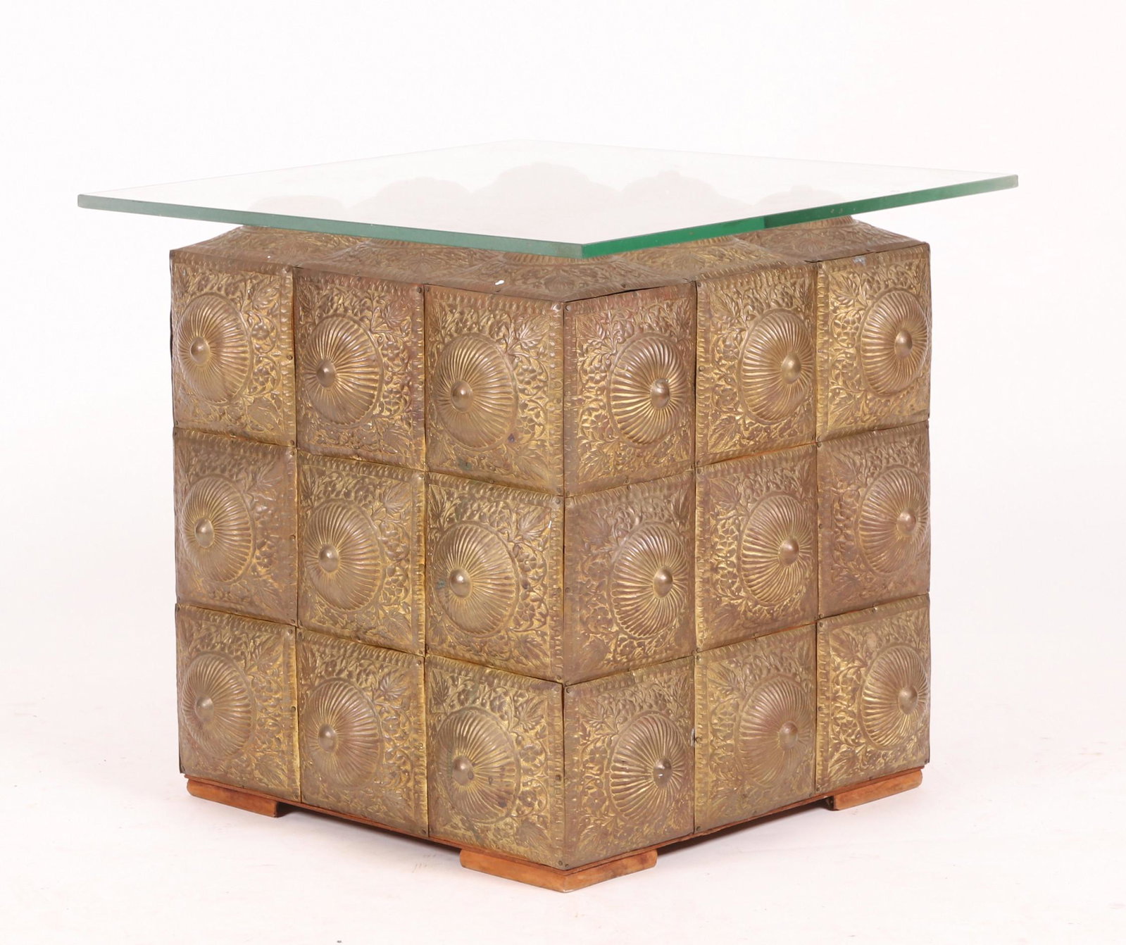 A Brass and Glass Table: A blocked cube form base with a glass top. Dimensions: The top is 23" x 21 1/2", the height is 21".