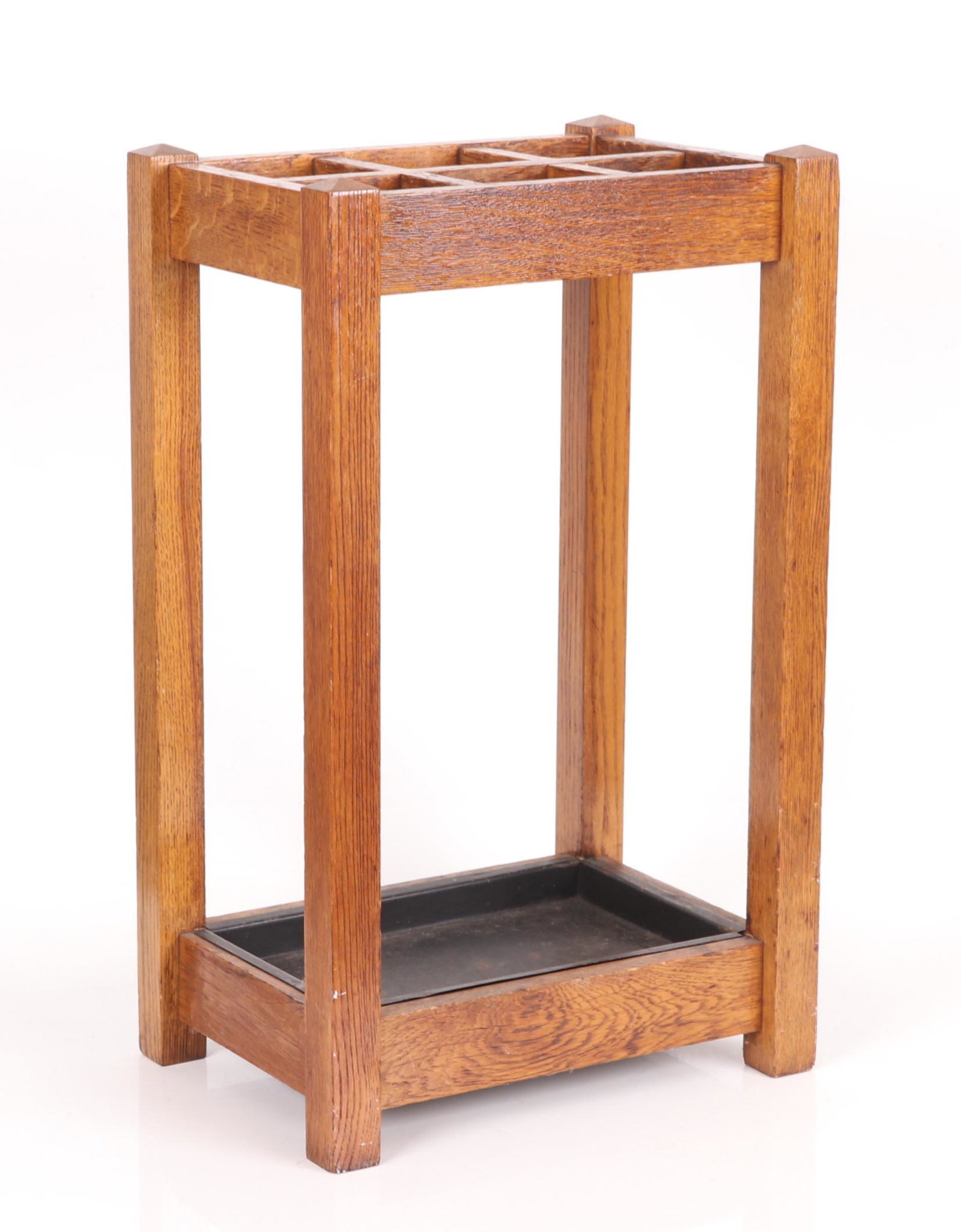 An Arts and Crafts Era Oak Umbrella Stand: Circa 1920, with a metal tray at the base. Dimensions: 12" x 17", the height is 28".