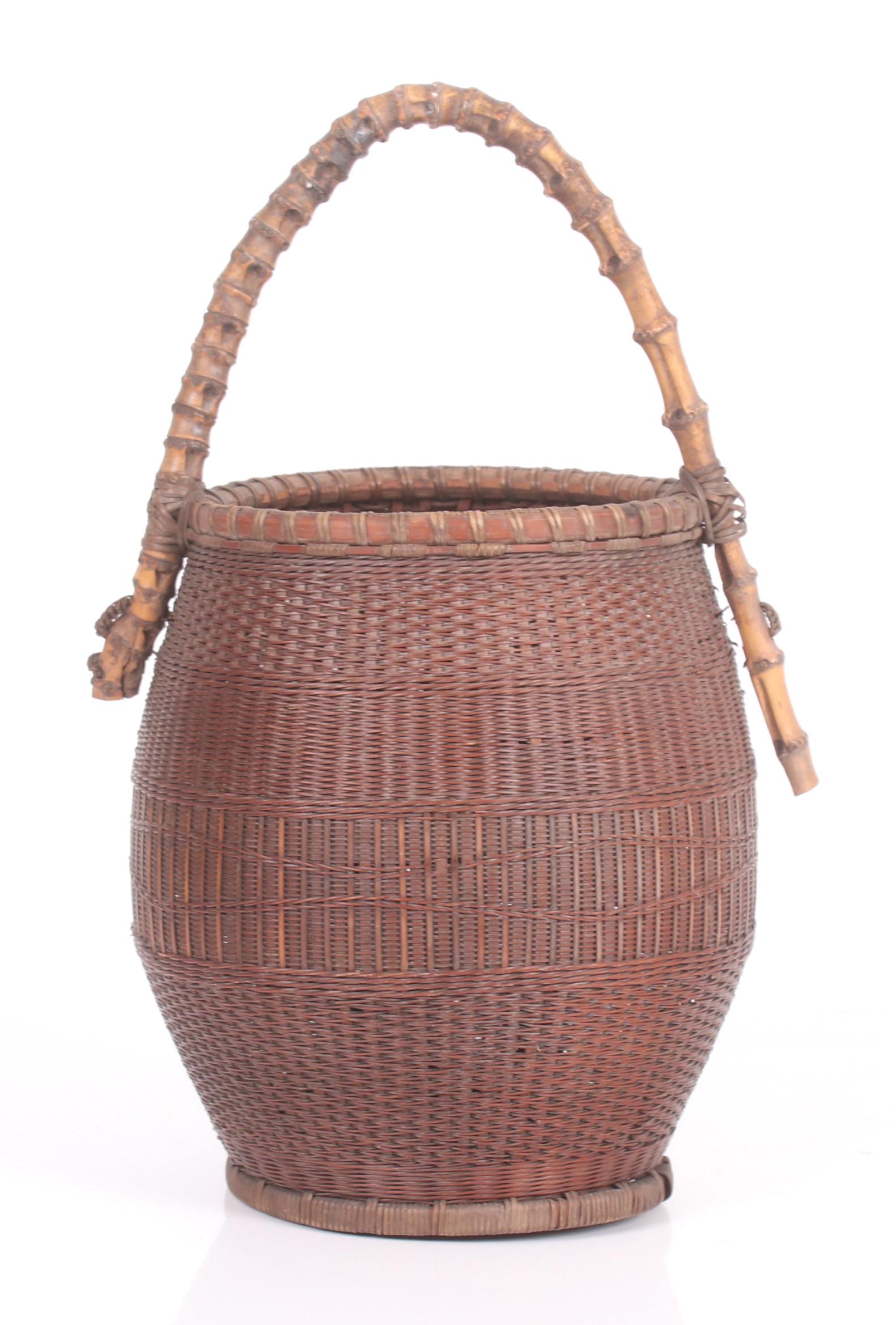 A Japanese Meiji Period Ikebana Basket: Late 19th or early 20th century, in an ovoid form and with a bamboo handle. Dimensions: 9" in diameter, 17" tall.