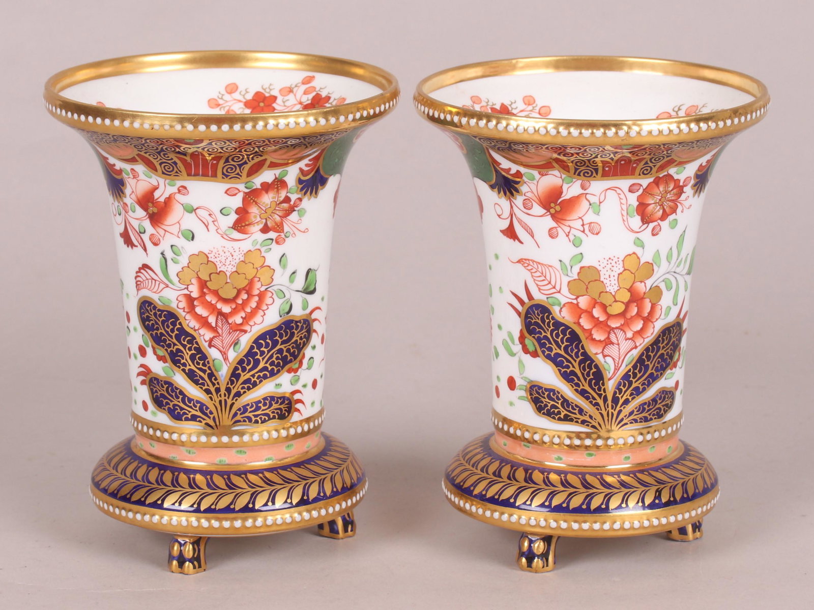 A Pair of Good Spode Porcelain Vases: Each with three paw feet below a foliate decorated gilt foot on a cobalt ground, below the trumpet form body which is decorated in the Imari style. Each marked as pictured. Dimensions: Each is 4 3/4" 