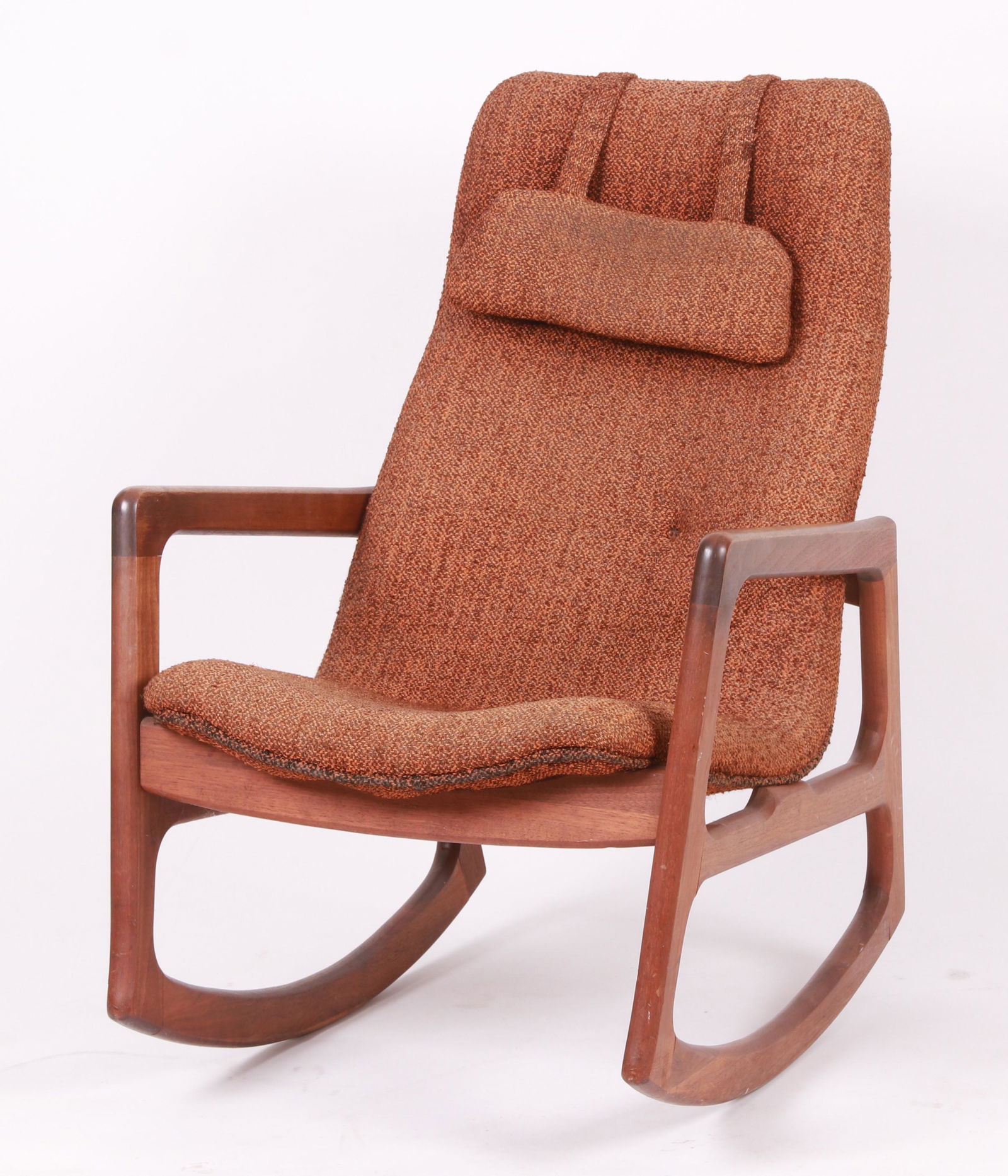 A Danish Modern Rocking Chair: Teak, with open arms and a tapered tablet back, with original weighted headrest. Dimensions:26" W x 32" D x 18.5" H (seat height), the overall height is 38". Provenance:From a Pottstown collection.