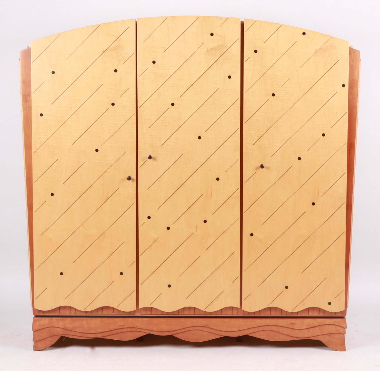 Ron Puckett, Custom Wine Cabinet: A postmodern style maple, cherry and ebonized wood inlaid wine cabinet, late 20th century, with three doors opening to interior racks and shelving above a wavy skirt and feet. Dimensions:65"h H x 65" 