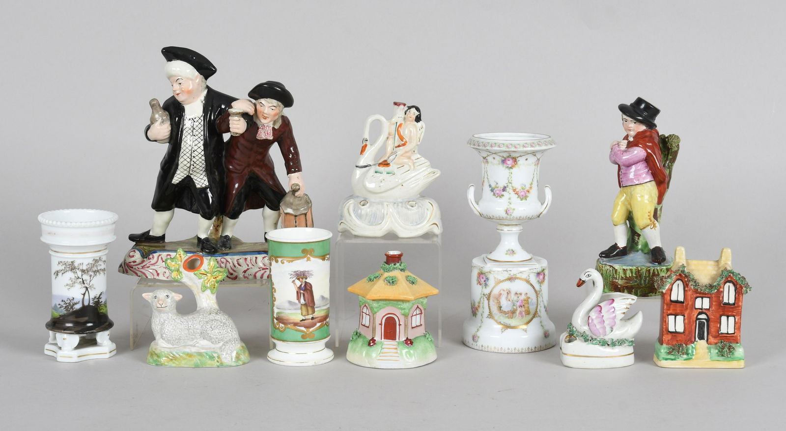 A Large Group of English and Continental Pottery: An assembled group of ten English pottery table decorations and others, late 19th-early 20th century, comprising a William Kent Staffordshire figural group: The Parson and Clerk; A William Kent Staffo