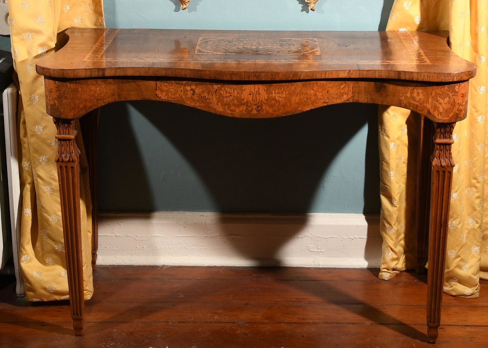 Italian Neoclassical fruitwood Inlaid Walnut Console: An Italian Neoclassical fruitwood inlaid walnut console, early 19th century and later, the rectangular serpentine top with shaped apron, raised on fluted square tapered legs. Dimensions:Height 32in; w