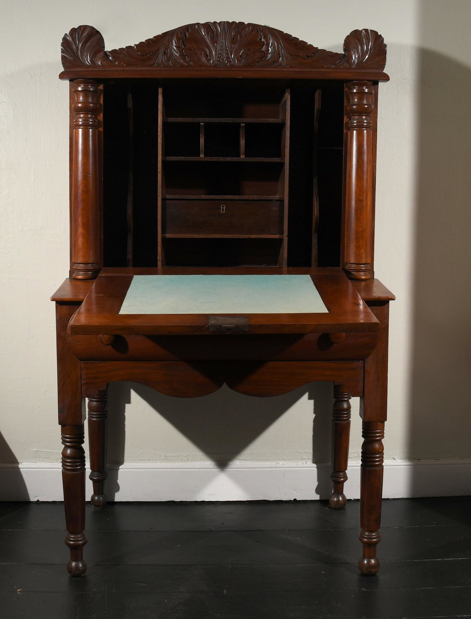 Pennsylvania Classical Fall Front Desk: A Pennsylvania Classical carved mahogany fall front desk, second quarter 19th century, the hinged fall enclosing a fitted interior with baize lined writing surface above a dovetailed drawer with shape